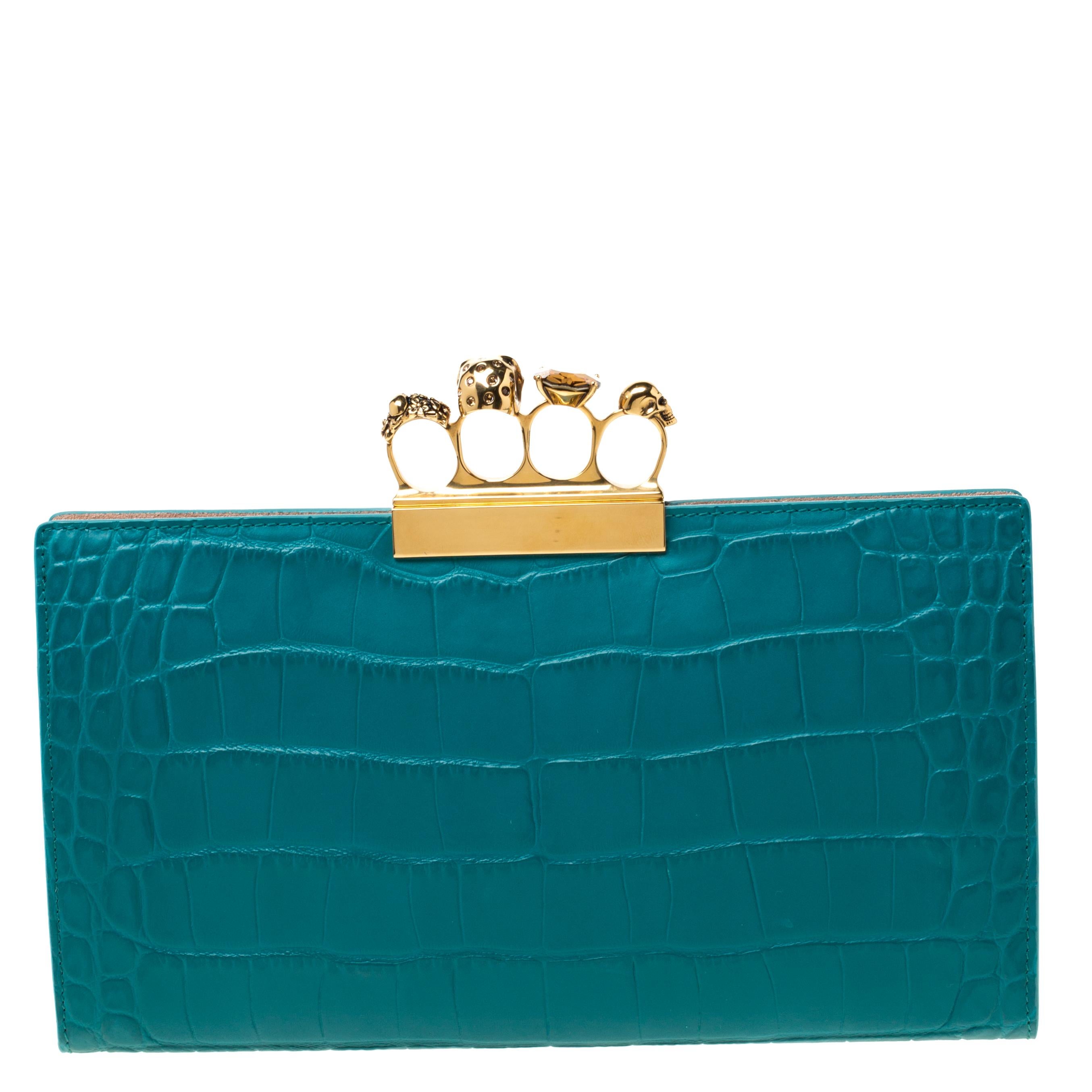 This Knuckle Clutch from Alexander McQueen exudes versatility and luxury. Lined with suede on the insides, it features a green croc-embossed leather exterior. This piece is complete with the brand's iconic skull knuckle clasp on the top. Flaunt this