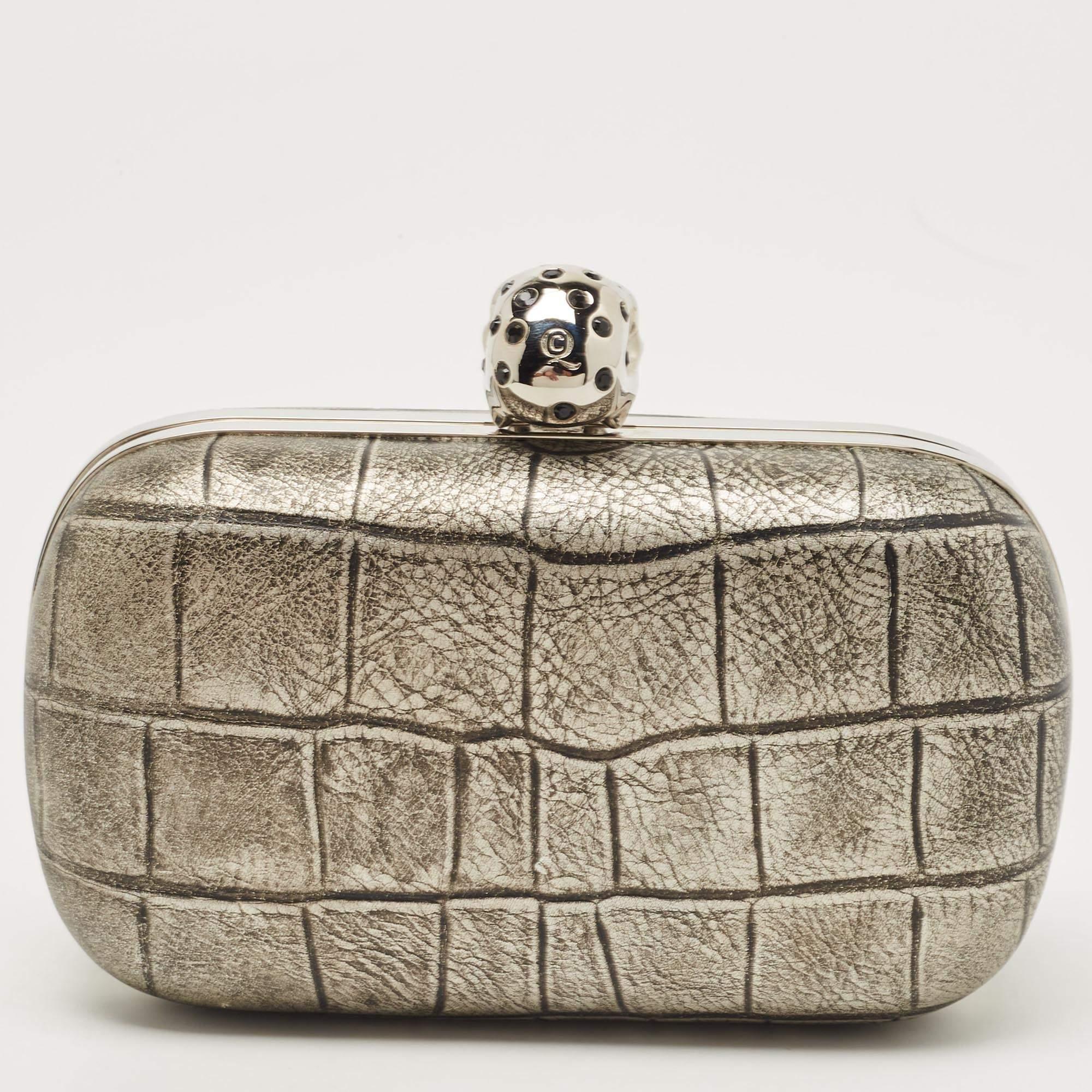 Add Alexander McQueen's signature touch to your closet with this clutch. Crafted from satin, this box clutch is embellished with crystals on the skull clasp. Its interior is lined with smooth leather and offers easy access to your little