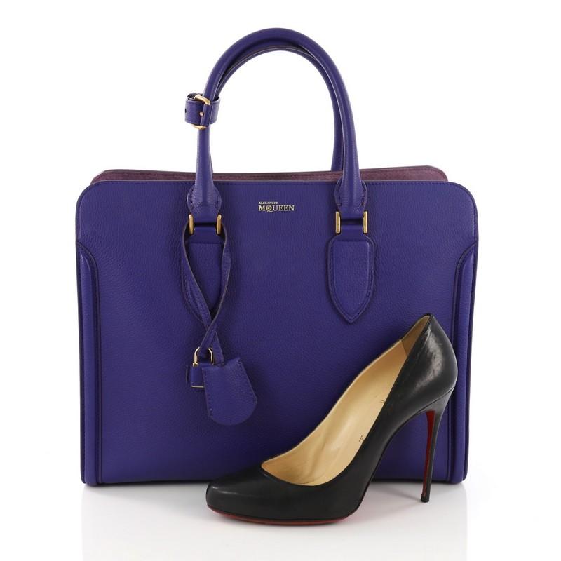 This Alexander McQueen Heroine Open Tote Leather, crafted in purple leather, features dual rolled leather handles, protective base studs, logo lettering, and gold-tone hardware. Its full-zip around closure opens to a purple suede interior with two