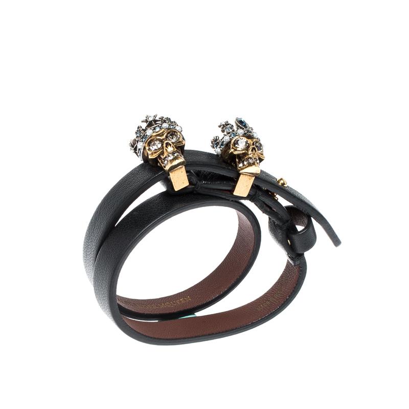 Alexander McQueen's love for skull motifs is seen not only in clothes and shoes but also in the brand's line of accessories. Carrying the very signature is this double wrap bracelet that has a leather strap holding two metal skull motifs. The skulls