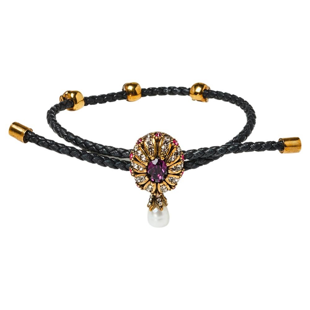 Alexander McQueen's love for skull motifs is seen not only in clothes and shoes but also in the brand's line of accessories. Carrying the very signature is this Friendship bracelet that has a woven leather strap holding a crystal-embellished oval