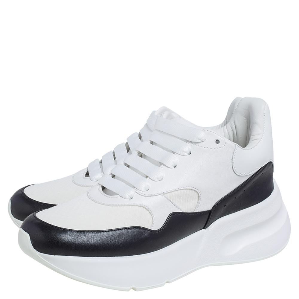 Let your latest shoe addition be this pair of sneakers from Alexander McQueen. These white and black sneakers have been crafted from leather and fabric and feature a low-top style. They flaunt round toes, tie-up fastenings, and brand logos on the