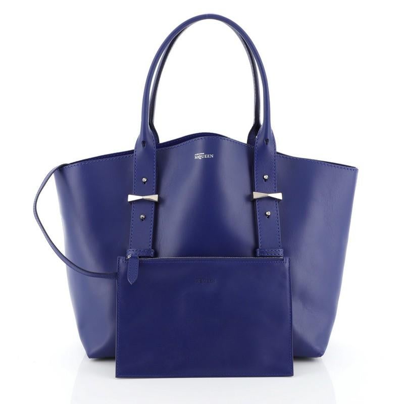 This Alexander McQueen Legend Tote Leather Medium, crafted in blue leather, features dual-rolled leather handles with belted leather details, protective base studs and silver-tone hardware. Its wide top opening showcases a blue suede and leather