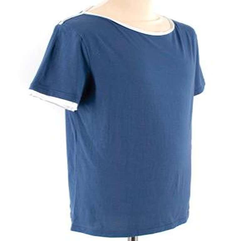 Alexander McQueen Blue Cotton T-shirt with White Trims 

-Made of soft cotton 
-Gorgeous blue hue 
-Round neckline 
-Distressed white trim detail to the neckline, shoulders and sleeves 
-Skull patches to the sides 
-Skull embroidery to the front