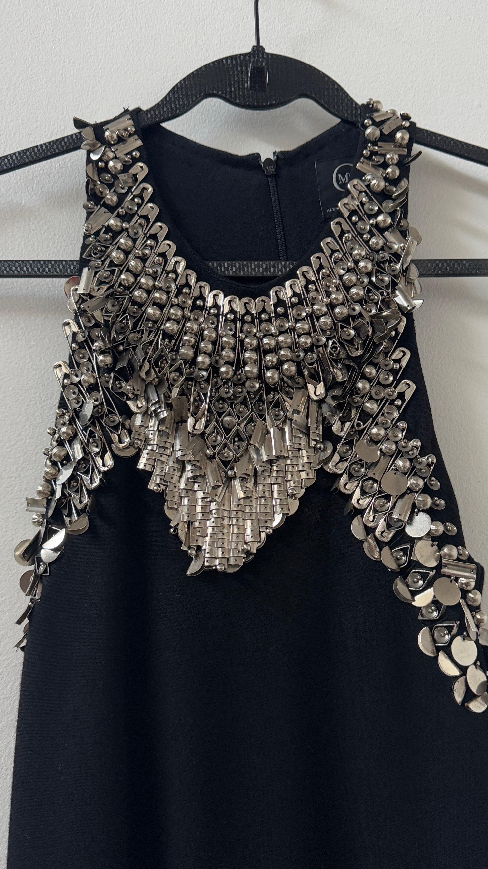 This breathtaking Alexander McQueen dress is a true masterpiece, encapsulating the brand’s daring and sculptural aesthetic with effortless sophistication. Designed to make a statement, it features an elegant halter-neck silhouette that gracefully