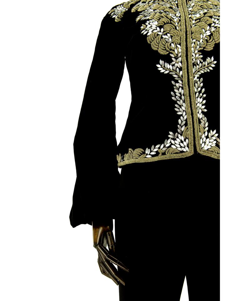 Veste en velours noir Alexander McQueen, ornée de broderies tridimensionnelles de fils métalliques dorés et argentés dans un motif de feuillage. Manches cloches froncées au poignet. Créée du vivant d'Alexander McQueen. La version du manteau existe