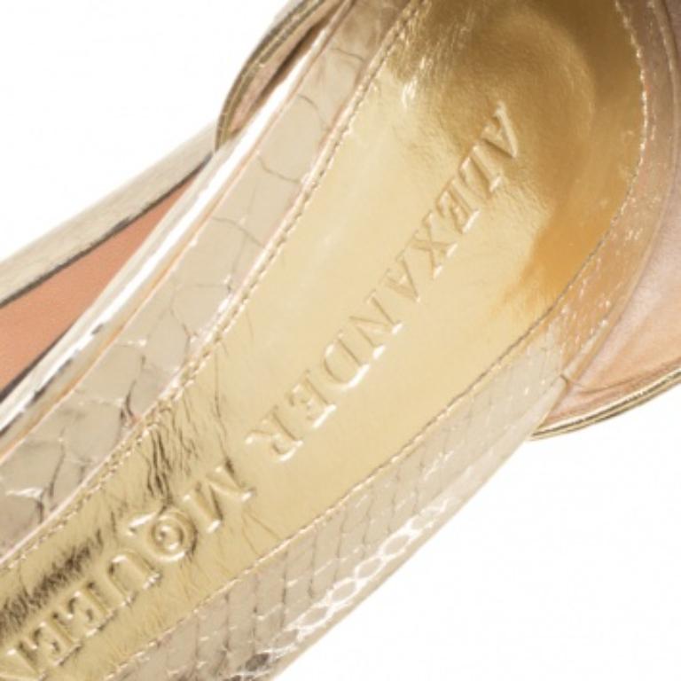 Ces sandales glamour signées Alexander McQueen sont méticuleusement confectionnées en cuir embossé de python métallique. Ces sandales sont dotées d'une finition brillante, de brides de cheville accentuées par des boucles en métal doré, de bouts