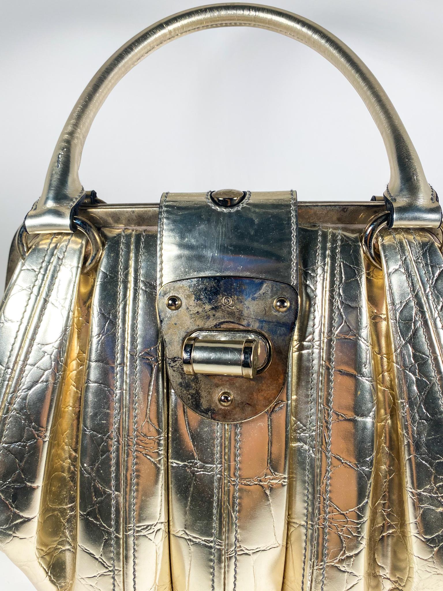 Dramatic structured pleats and chunky turn lock clasps call for a mid 2000’s revival. Made with embossed patent leather, gold-tone hardware, and a fabric lined interior. 

Condition: Okay used condition.
Exterior: Oxidation, discoloration and some