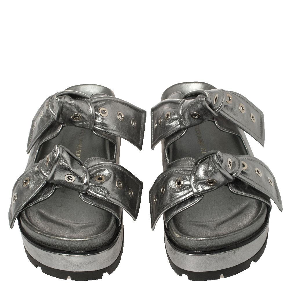 You'll find excuses to wear these slide sandals from Alexander McQueen that are all about comfort and effortless style! These sandals are crafted from metallic grey leather and are styled with rivet-accented straps on the front that carrying bow