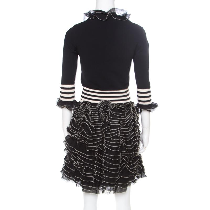 This top and skirt set from Alexander McQueen are perfect for an evening look. The monochrome top has a round neckline and three-fourth sleeves, both accented with ruffled trims and a comfortable fit. The gorgeously ruffled skirt features a banded