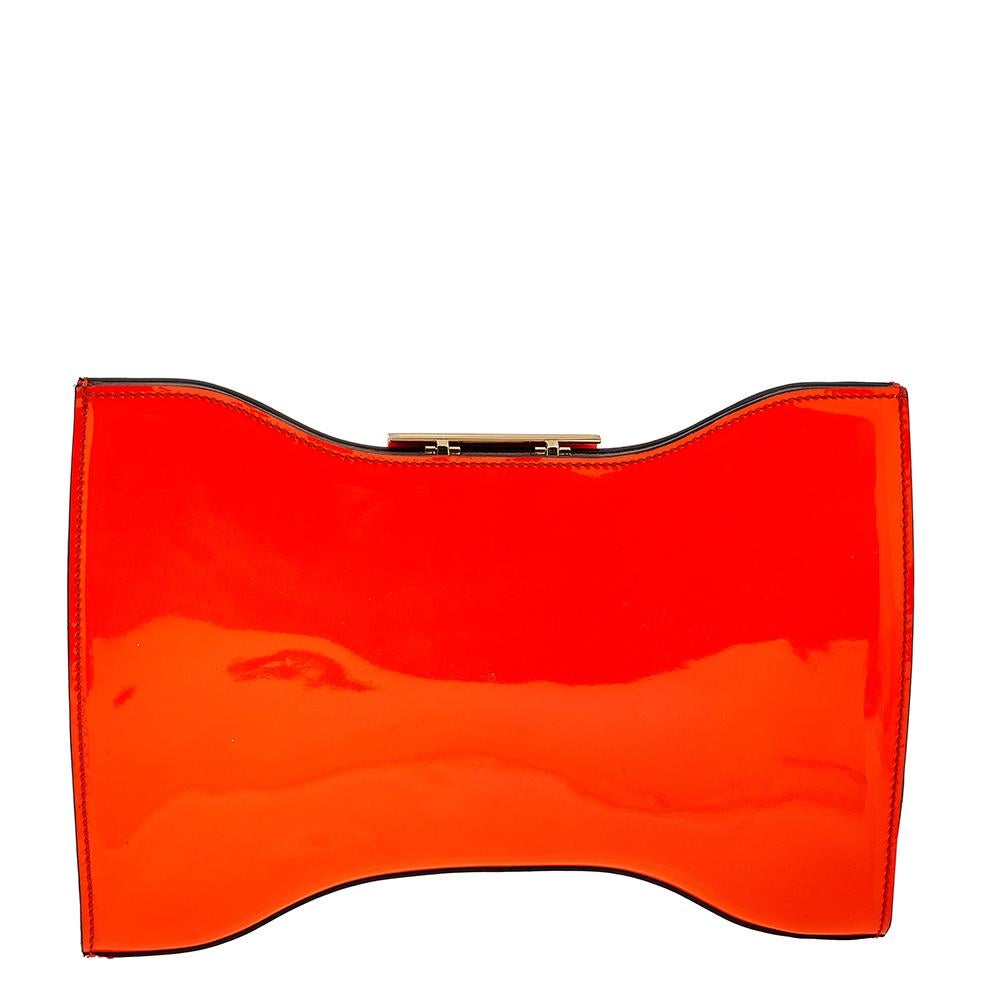 This elegant clutch from Alexander McQueen is easy to carry without compromising on style. Crafted from neon orange patent leather, the clutch features a gold-tone metal lock on top. The interior is leather-lined and has a zip pocket.

