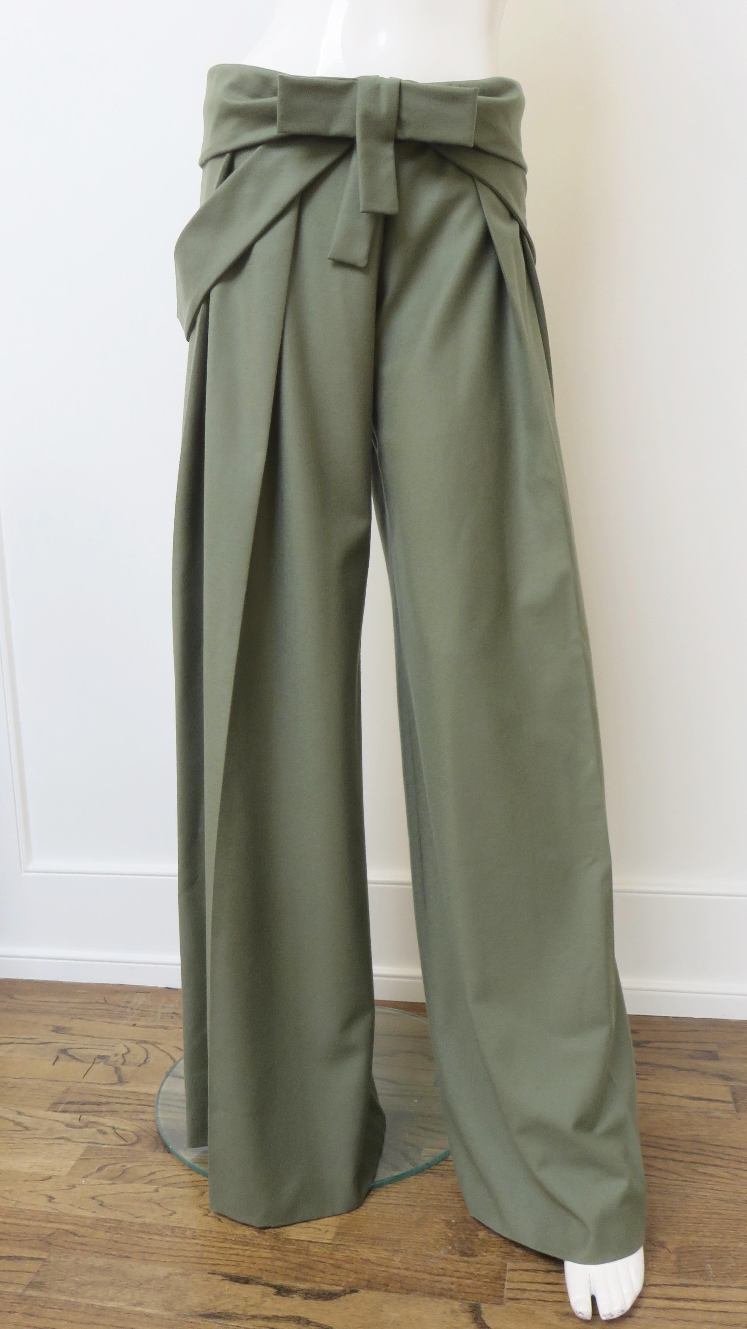 Beautiful green cashmere wide leg pants by Alexander Mcqueen.  They are mid rise and have a ruched waistband with a front bow, front zipper and bands which loop through bound openings on each side and drape along the sides of the legs. The pants