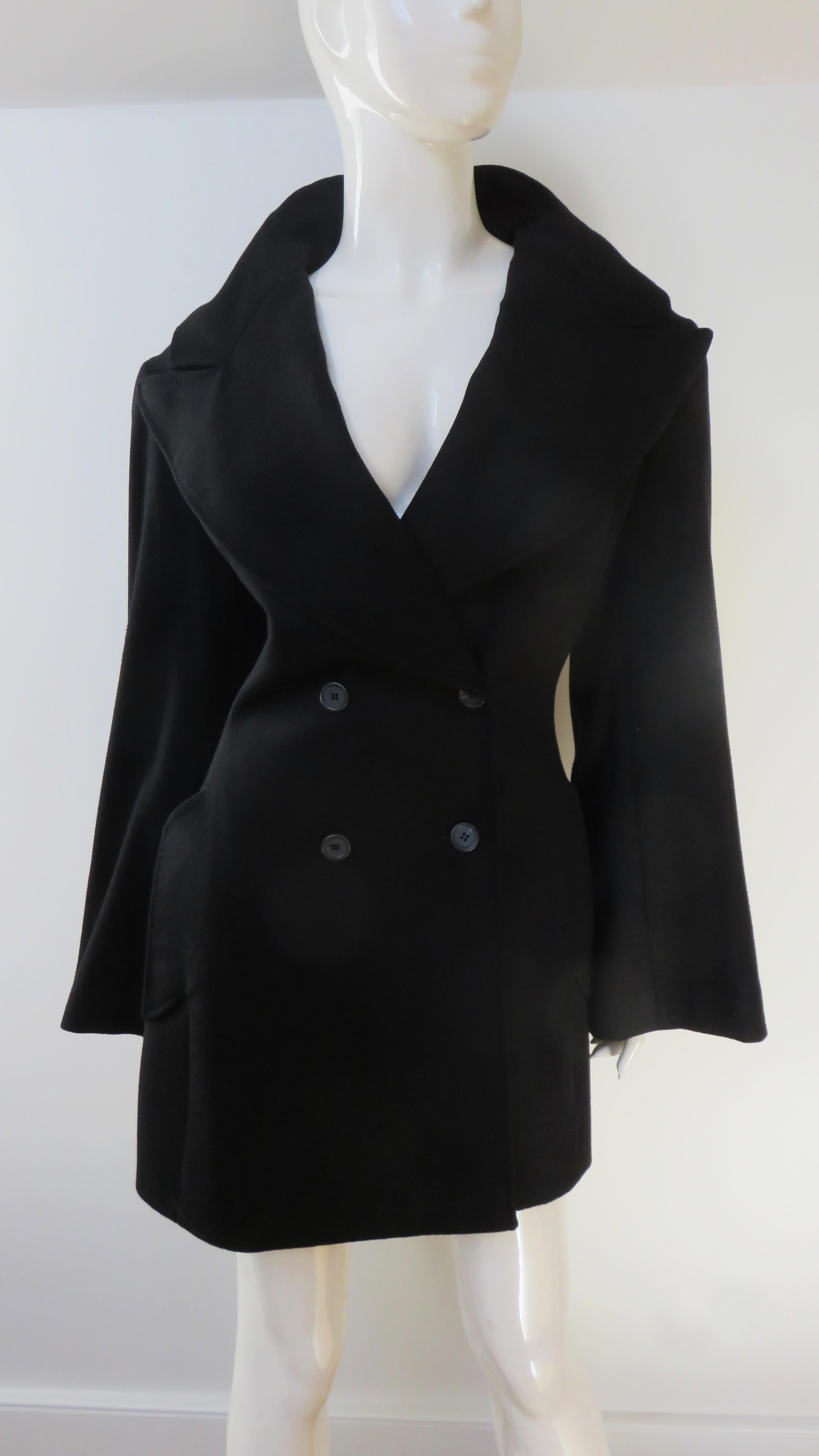 Cette fabuleuse mini robe noire en cachemire mélangé à col montant est signée Alexander McQueen. Il est doté d'un double boutonnage, d'un col à revers qui encadre joliment le visage, de poches à rabat sur les hanches et de manches longues complètes.
