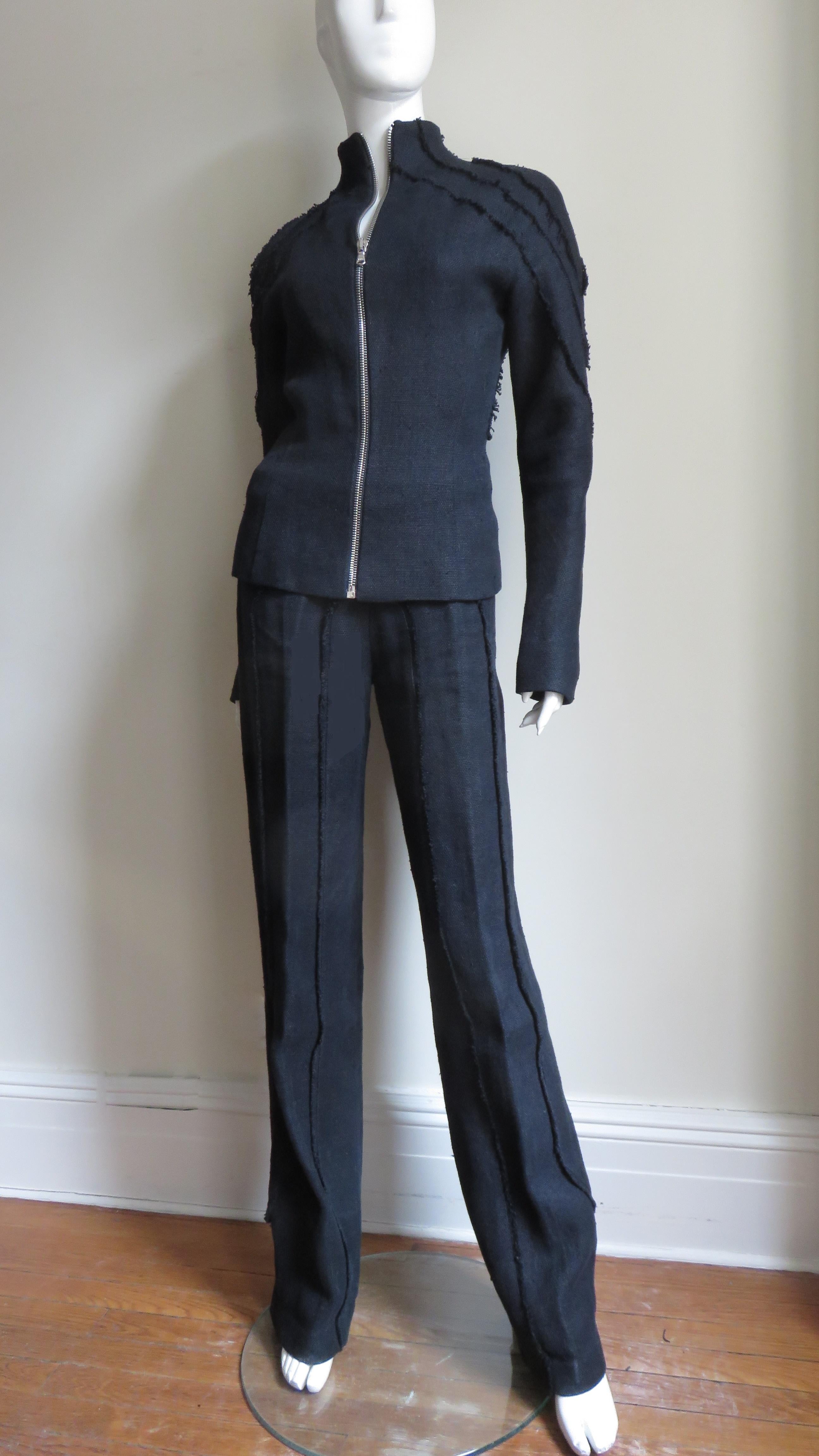 An incredible mid weight black linen jacket and pant set from Alexander McQueen. The jacket has a stand up collar, long sleeves and an elaborate pattern of raw edge panels along the shoulders, sleeves and in flattering angles in the back.  It is
