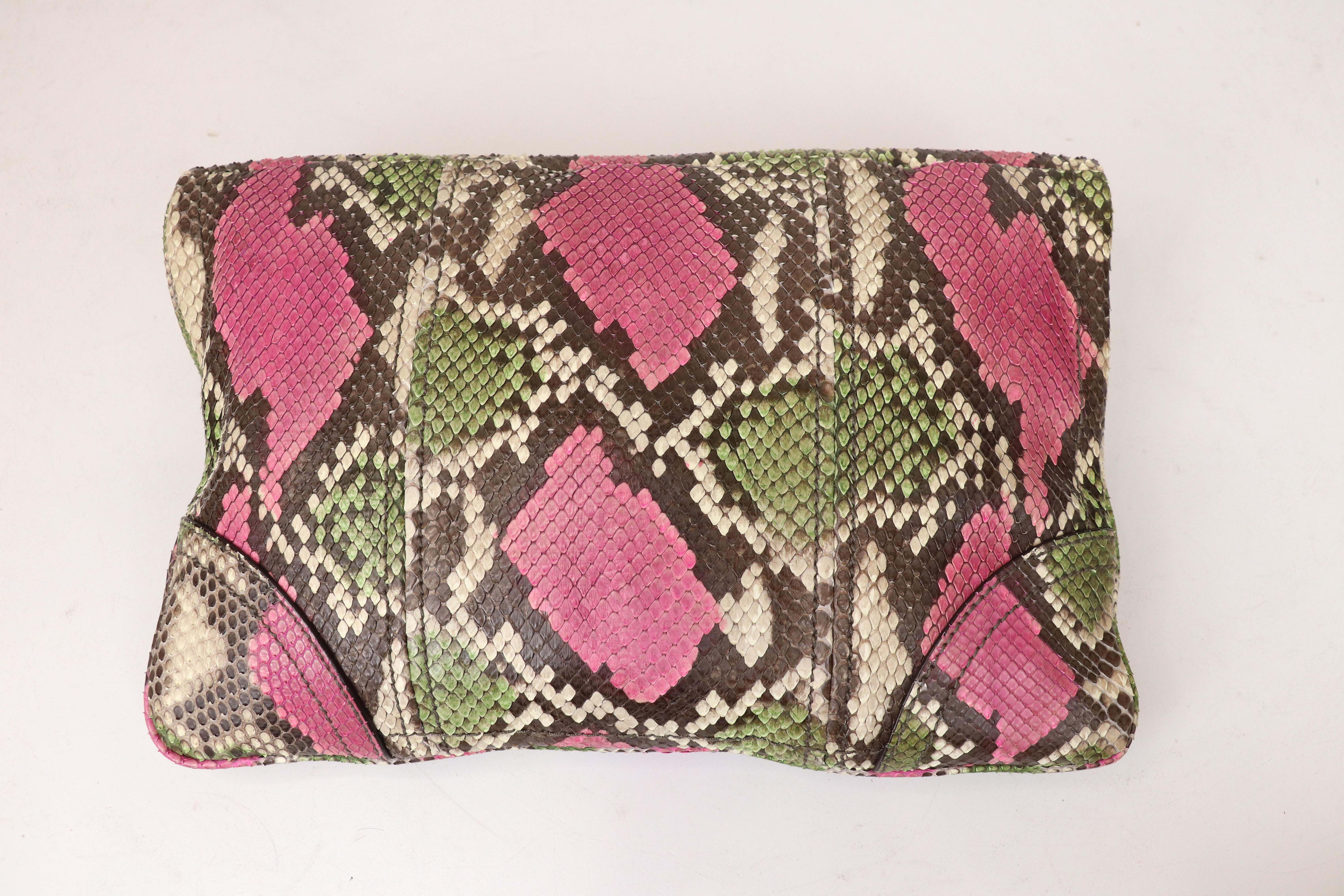 This fabulous Novak clutch, by Alexander McQueen, showcases black and white python snakeskin with green and pink, a very rare and difficult color combination to come across. Clutch has a large snakeskin covered turn lock closure at the front, iconic