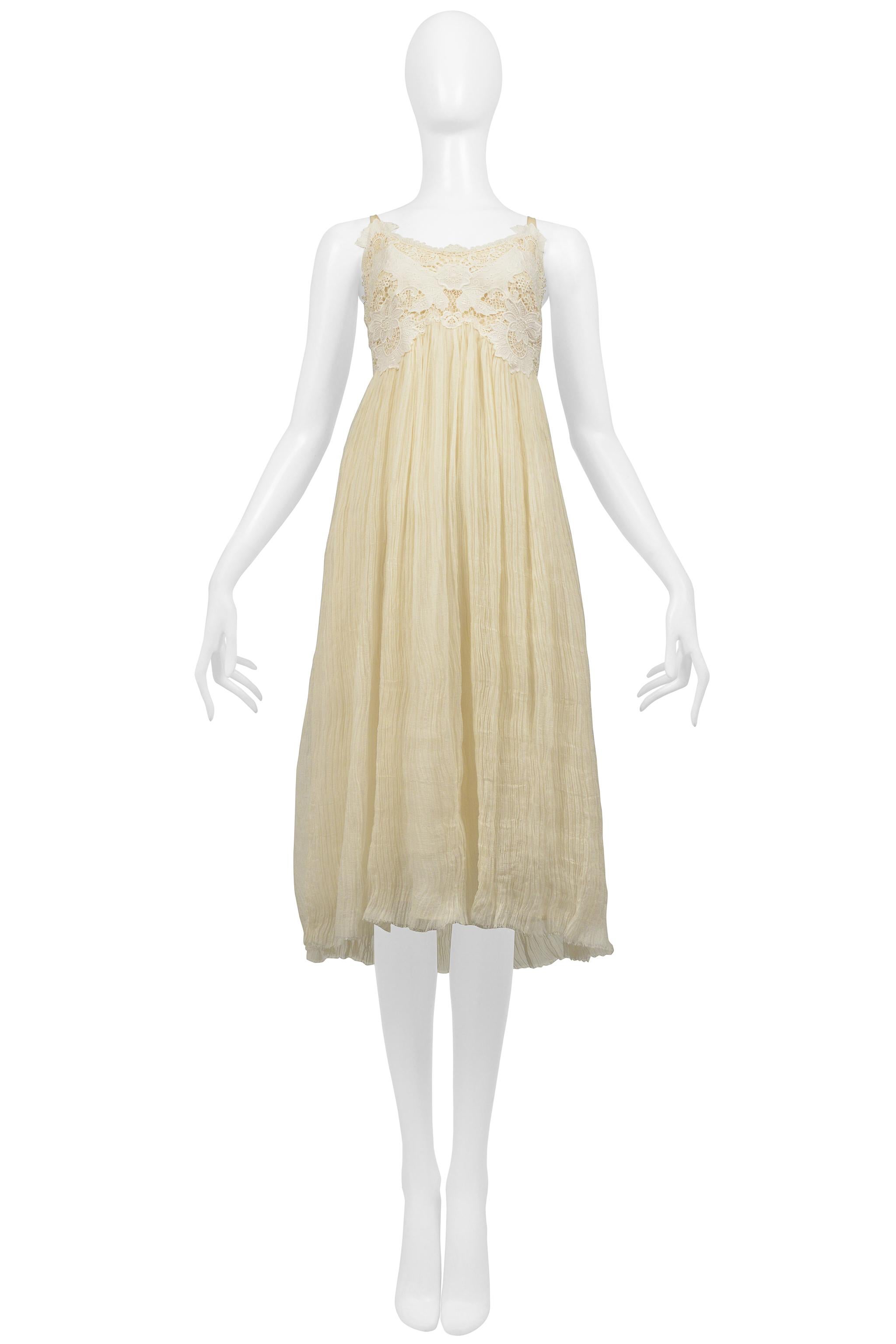 Resurrection Vintage a le plaisir de vous proposer une robe vintage Alexander McQueen blanc cassé de la collection 2005 avec un corsage en dentelle, un corps froissé avec un ourlet à bords bruts, des bretelles spaghetti, une longueur midi et une