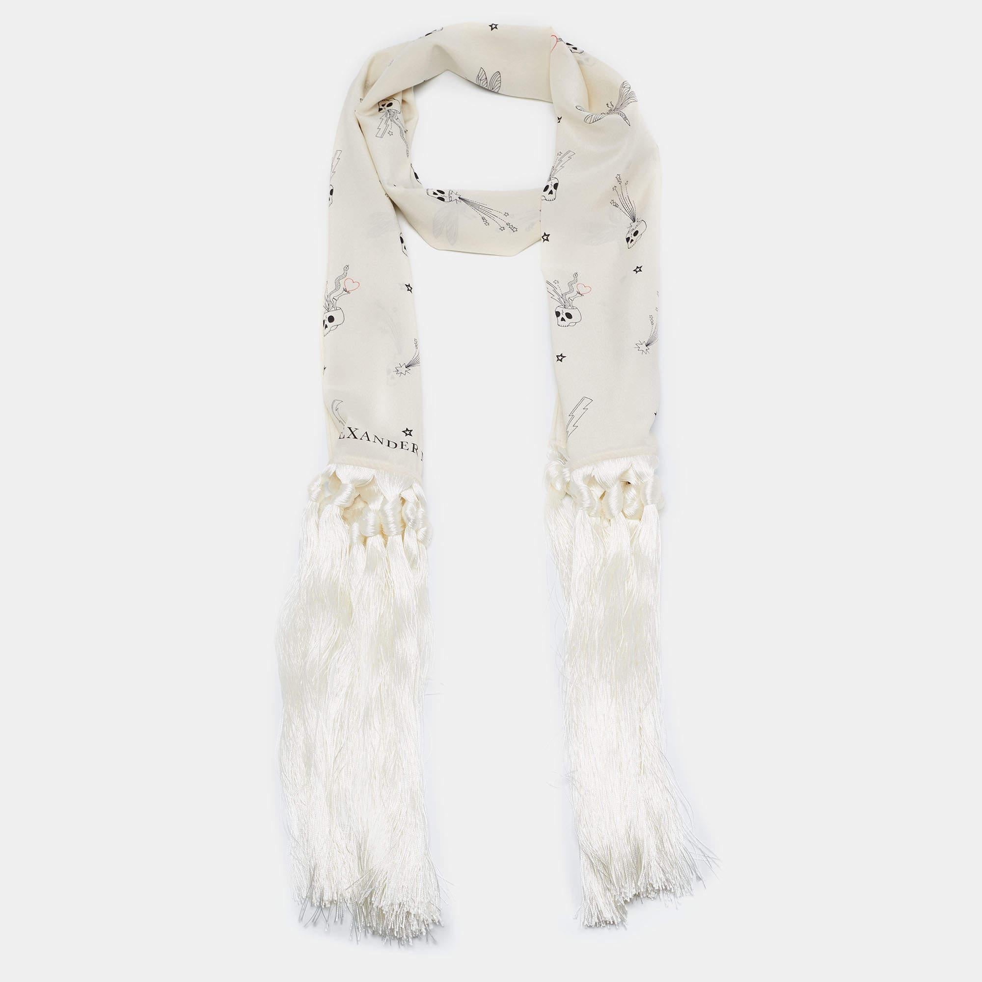 The Alexander McQueen stole is a luxurious fashion accessory. Made from exquisite silk, it features a captivating skull print in shades of off-white, exuding a sense of edgy elegance. The stole is adorned with delicate fringes, adding a touch of