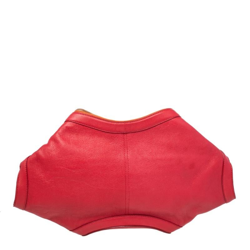 Alexander McQueen's De Manta clutch stands out because of its unique shape. It has shades of orange and red, folded top edges, and double zippers that lead to a lined interior.

Includes: Original Dustbag
