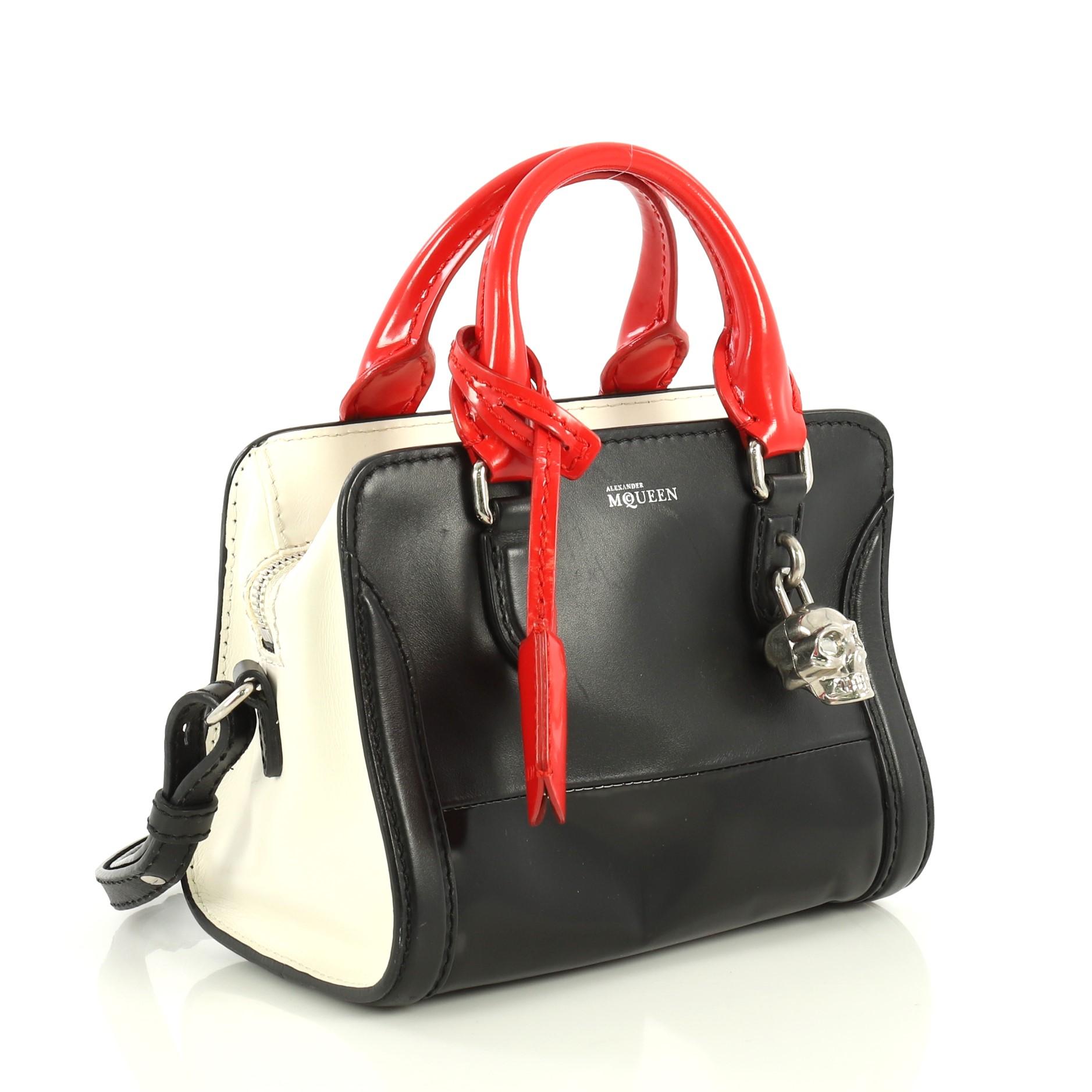 This Alexander McQueen Padlock Zip Around Tote Leather Mini, crafted from black and multicolor leather, features dual rolled handles and silver-tone hardware. Its zip closure opens to a black fabric interior with side zip and slip pockets.