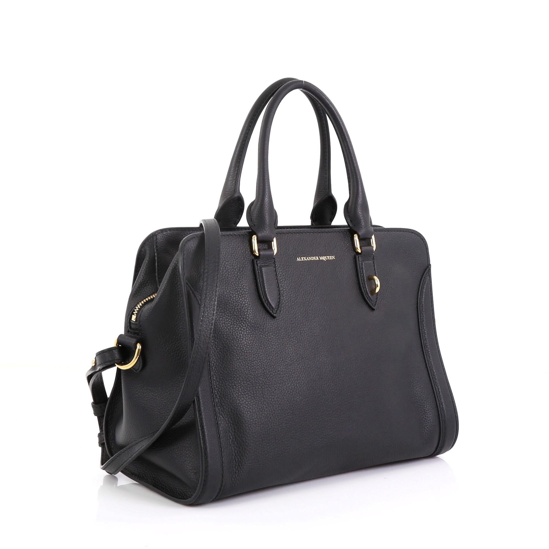This Alexander McQueen Padlock Zip Around Tote Leather Small, crafted from black leather, features dual rolled handles and gold-tone hardware. Its zip-around closure opens to a black fabric interior with zip and slip pockets. 

Estimated Retail