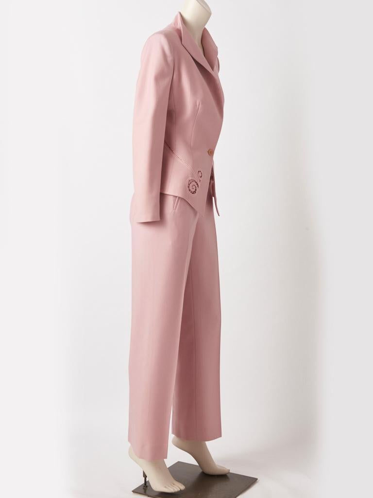 Alexander McQueen, dusty rose, wool pant suit, having a fitted bodice, a stand up collar and a single button closure. Pants are straight leg with a fly  front closure having slash pockets at the hips. Jacket has subtle embroidered lace-like