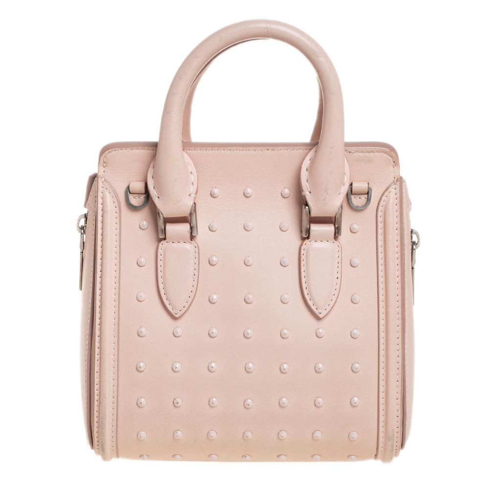 Every woman needs a bag that is pretty and functional, just like this Heroine shoulder bag from Alexander McQueen. Crafted from leather, it is styled with studs on the exterior, a suede interior, two top handles, and a shoulder strap. This is