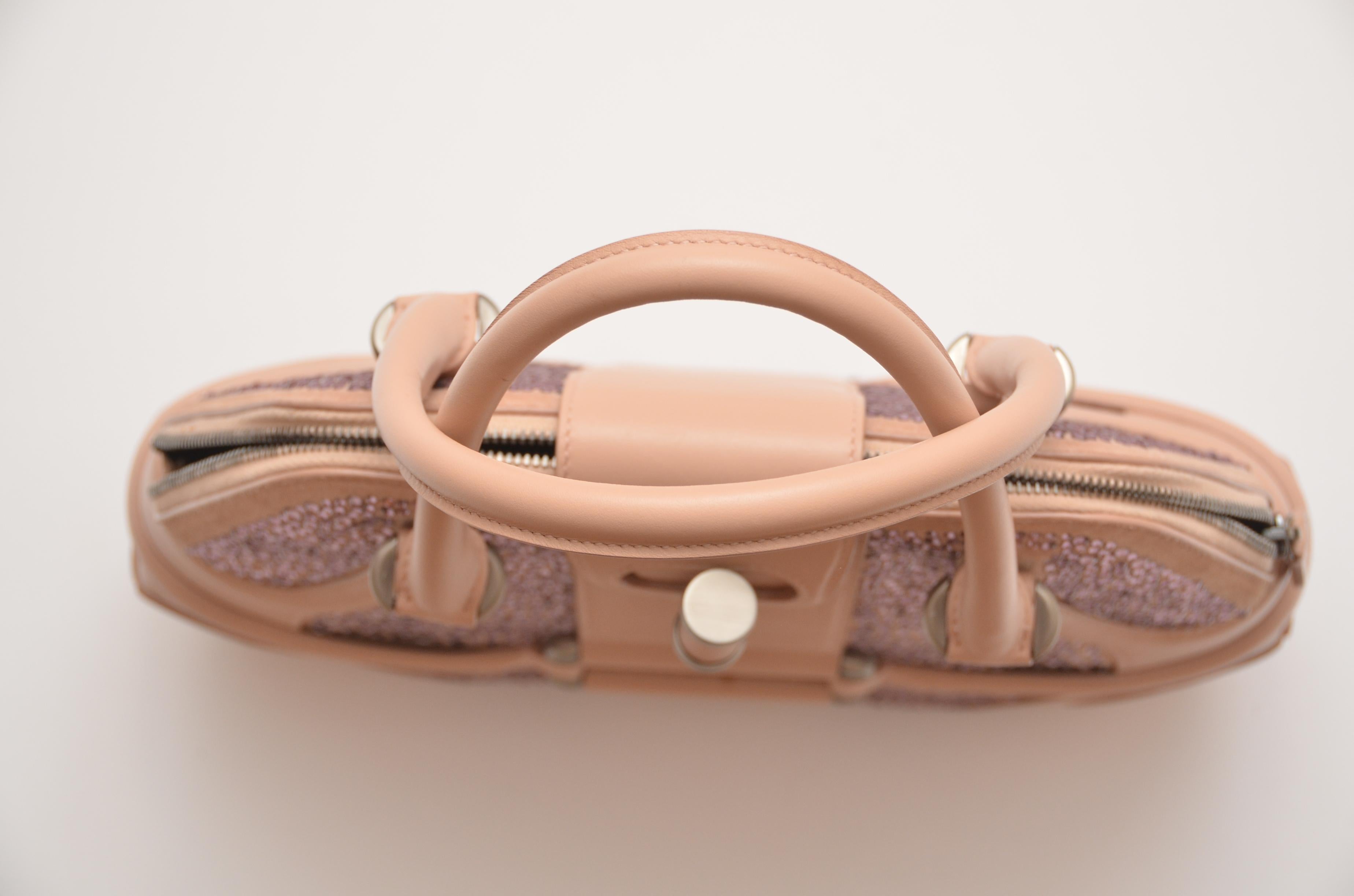 Exclusive Re-Edition for Harrods. 
Pink suede and leather Alexander McQueen Novak bag with brushed silver-tone hardware, dual rolled top handles.
Swarovski crystal embellishments throughout exterior, protective feet at base, black suede lining,