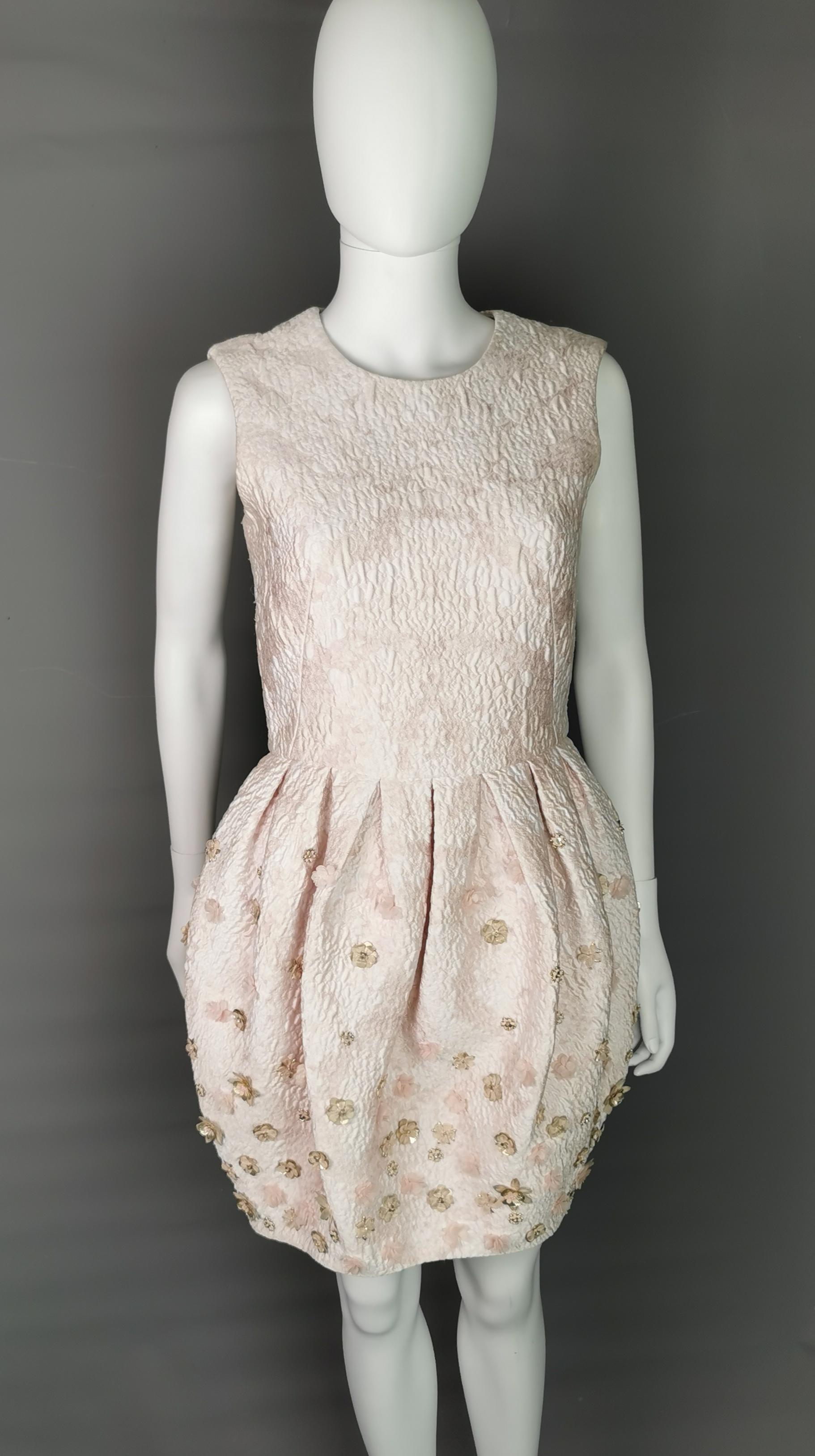 An absolutely gorgeous, dreamy dress by Alexander McQueen.

This is a light pink, silk blend jacquard dress, very beautiful thick embossed fabric with varying tones of pink.

The bodice is fitted, sleeveless and the dress has a wonderful full