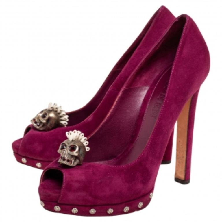 Cette paire d'escarpins signée Alexander McQueen se caractérise par un design raffiné et une confection exquise. Confectionnés en daim violet, ces escarpins sont ornés de motifs de têtes de mort sur le dessus. Intemporels et élégants, ils sont