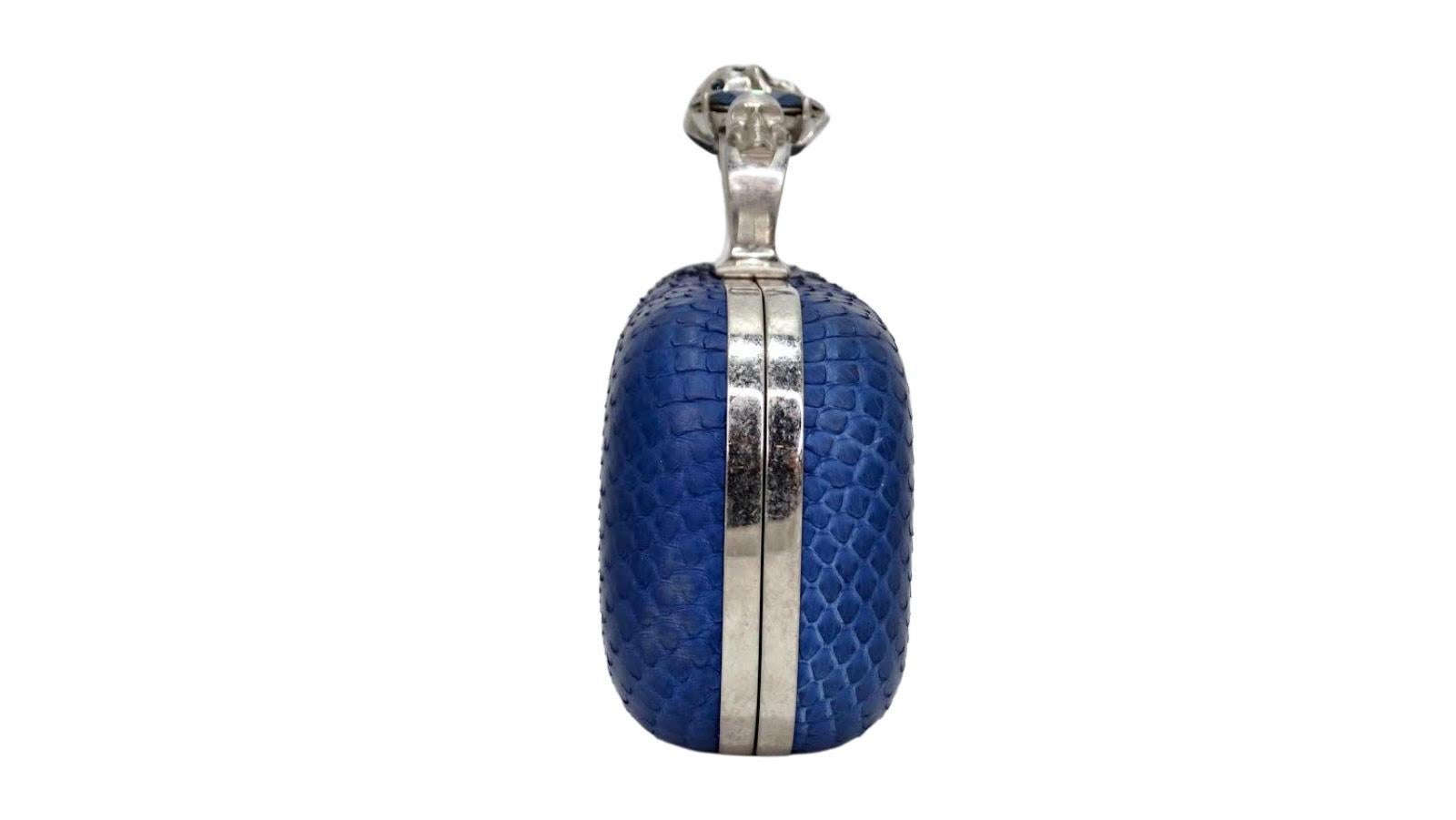 Elevate your look with this amazing Alexander McQueen knuckle buster clutch! Circa 2010 from his S/S collection, this clutch is crafted from blue python features gun metal hardware and a brass knuckle clasp embellished with McQueen’s signature