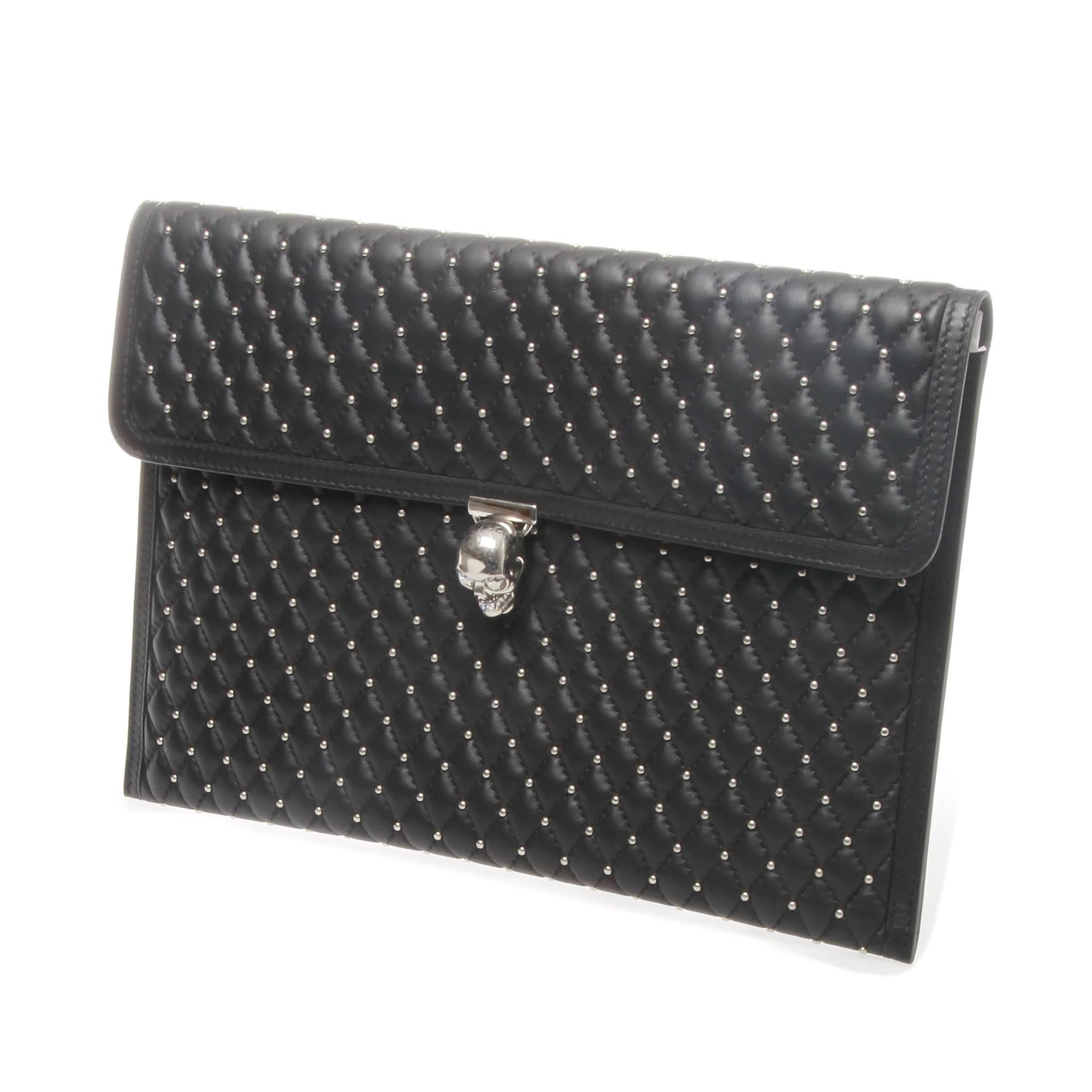 Alexander McQueen pouch clutch in black pad quilted leather featuring silver hardware studding and the iconic skull. 

Closure: Swarovski crystal encrusted skull with twist mechanism

Comes with authentic box