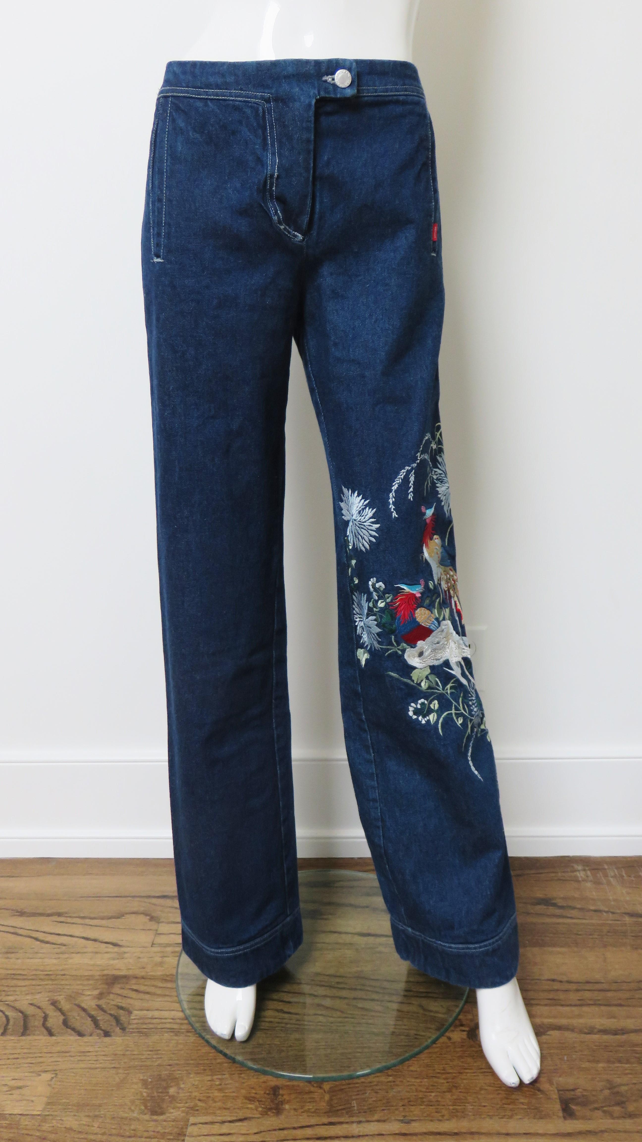 Incredible embroidered blue jeans by Alexander McQueen from one of his early notable early collections.  They are mid rise with straight legs and fabulous, intricately detailed, colorful embroidered birds along one leg from thigh to hem. The back