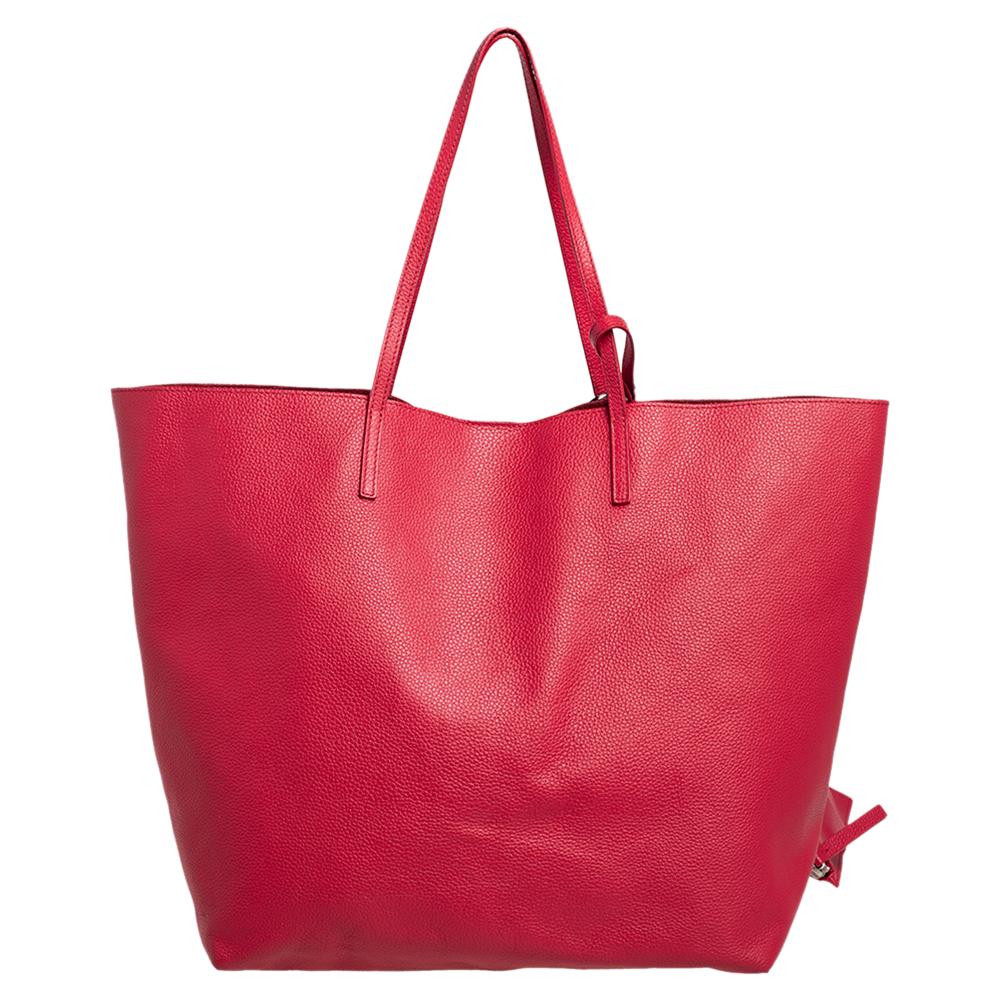 A timeless creation from the house of Alexander McQueen, this shopping tote is full of charm. Crafted from leather, it features a red exterior and a skull charm on the front. The tote comes with two handles and its interior will dutifully hold all