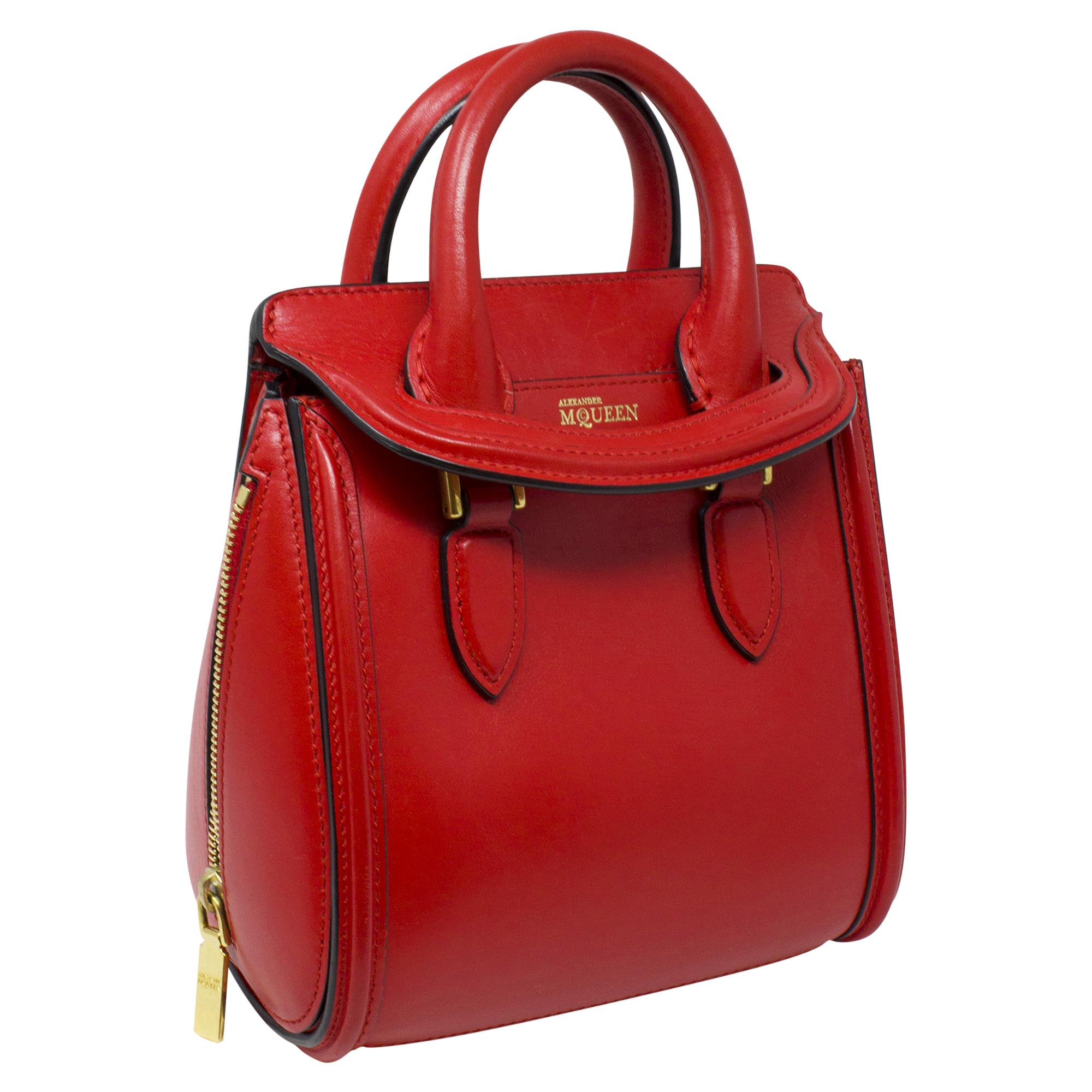 Introducing the Alexander McQueen Red Top Handle Bag, a bold and striking accessory for the fashion-forward individual. Crafted from vibrant red calfskin leather, this bag exudes confidence and style. With its sleek design and silver hardware