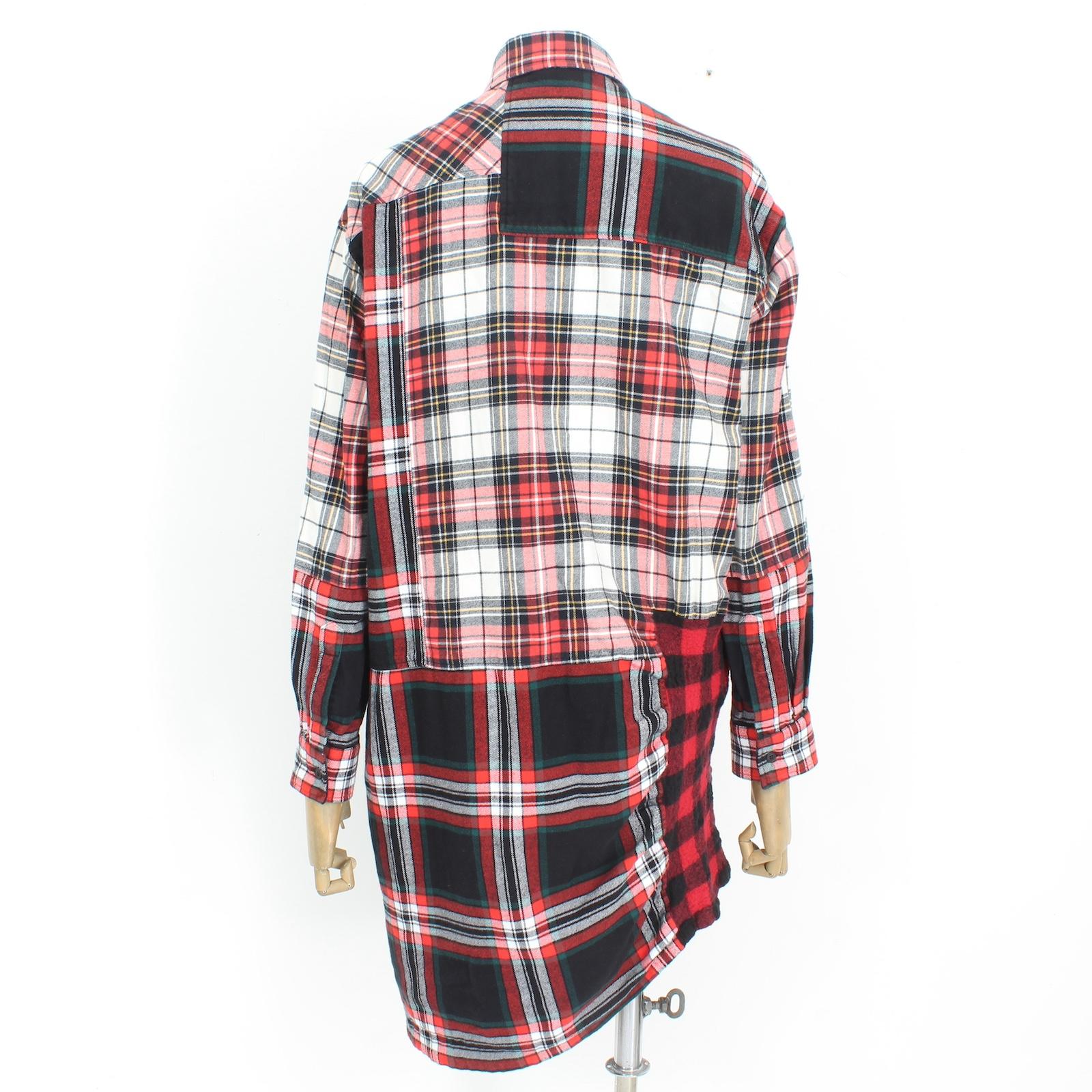 The Alexander McQueen Red Check Dress from the 2000s is a versatile addition to any wardrobe. Made from a blend of cotton and wool, this long shirt-style dress features a striking red, white, and black check pattern. The asymmetric closure adds a
