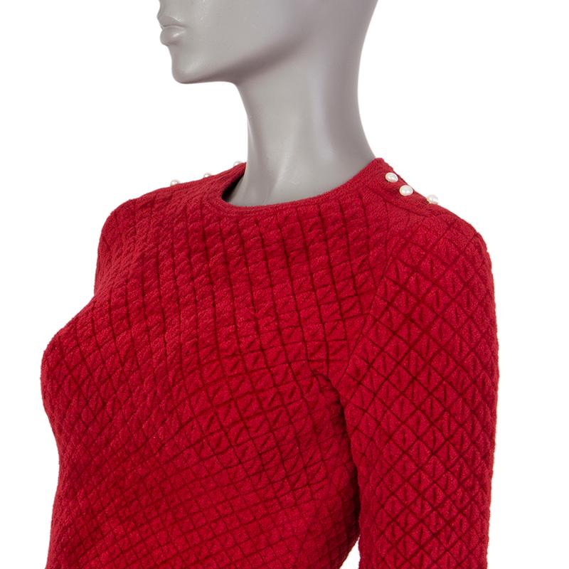 Alexander McQueen quilted sweater in red wool (39%), rayon (33%), polyamide (24%), and polyester (4%) with scalloped hemlines, and three pearl-embellishments on both shoulders. Unlined. Has been worn and is in excellent condition. 

Tag Size S
Size