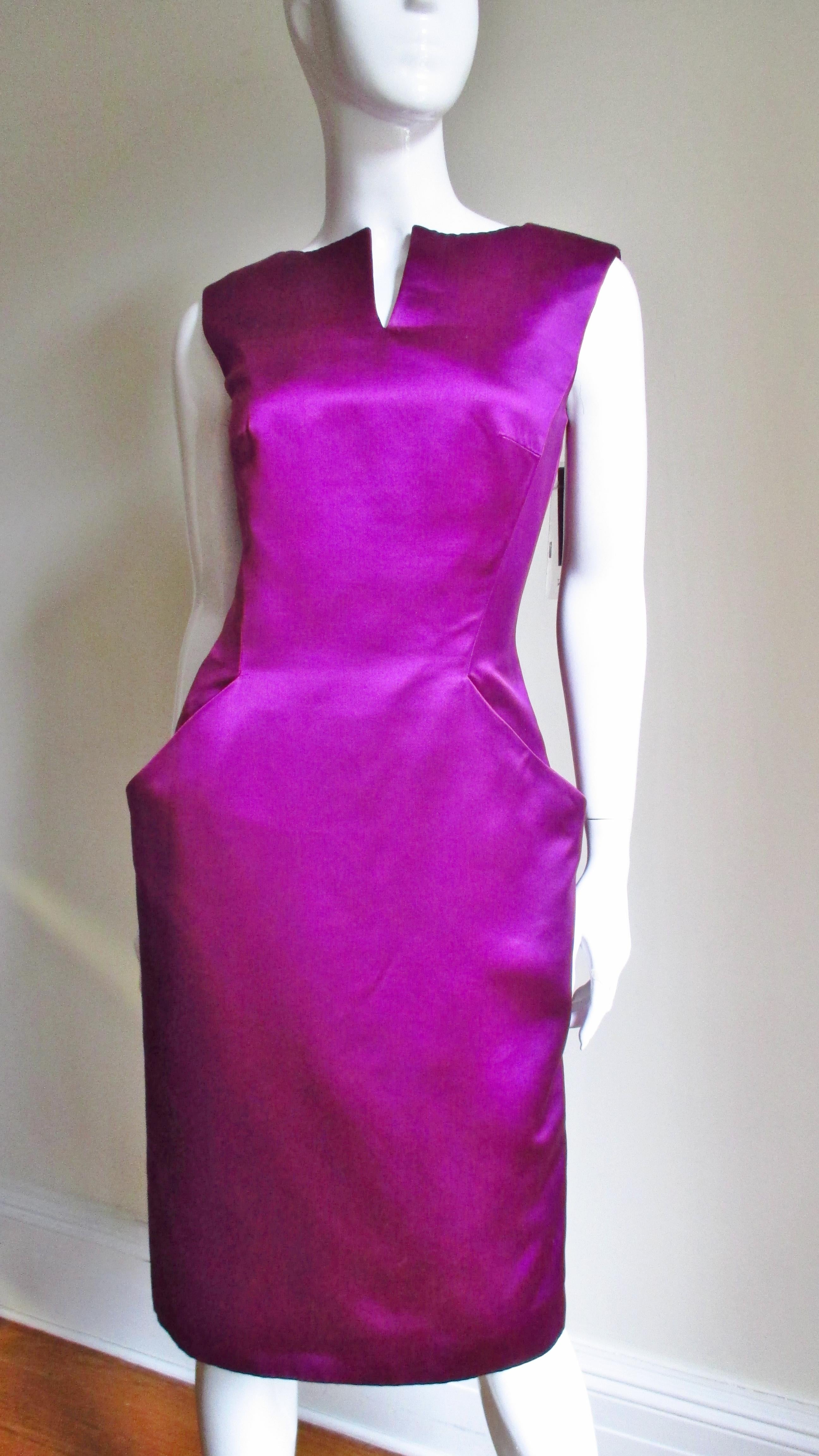 A fabulous dress of a bright fuchsia heavy weight silk from Alexander McQueen.  It is cut fabulously with a slit at the neckline and fitted waist. The center front sleeveless bodice is in one piece extending down into angled pockets creating clean