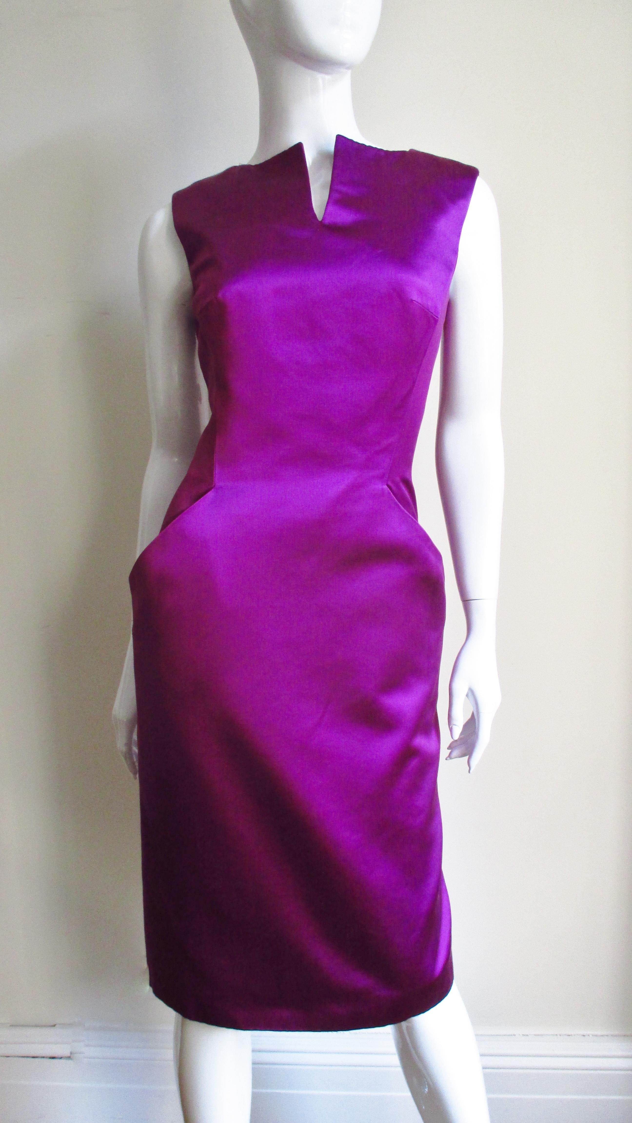 A fabulous fuchsia purple silk dress from Alexander McQueen. It is sleeveless with a slit at the center front neckline and hip pockets incorporated into the clever front seaming. The dress back has a deep V cut to the waist and a kick pleat at the