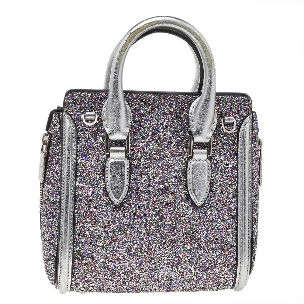 Every woman needs a bag that is pretty and functional, just like this shoulder bag from Alexander McQueen. Crafted from glitter and leather, it has been styled with a flap leading to a spacious suede interior and it is held by two top handles. This