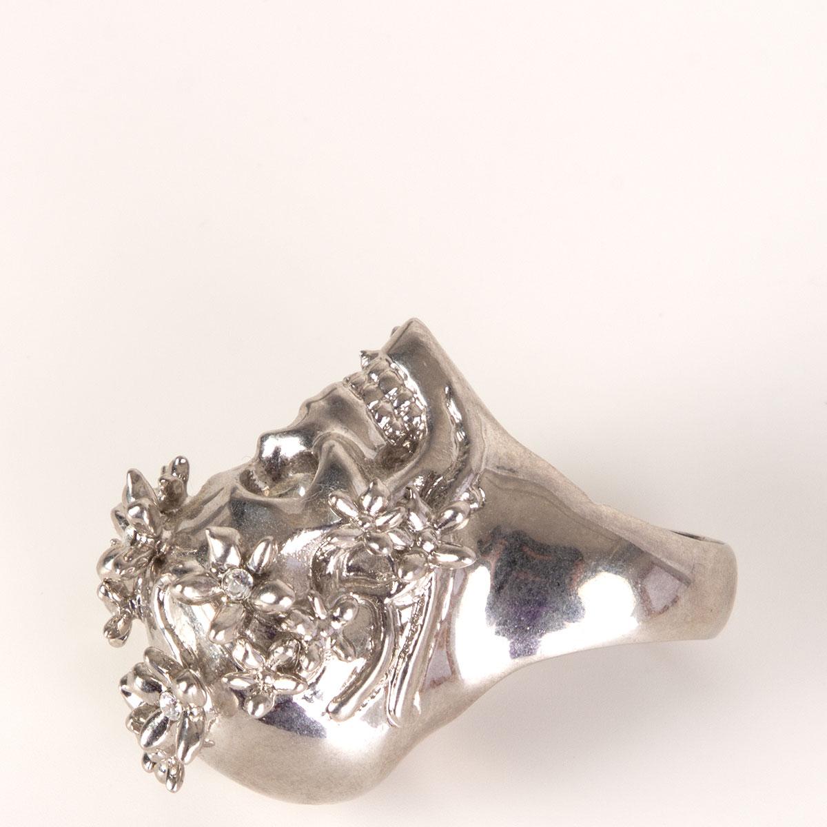 Alexander McQueen skull ring in silver-tone brass with crystal eyes and flower embellishments. Has been worn and is in excellent condition.

Tag Size 7
Width 3cm (1.2in)
Length 3cm (1.2in)

