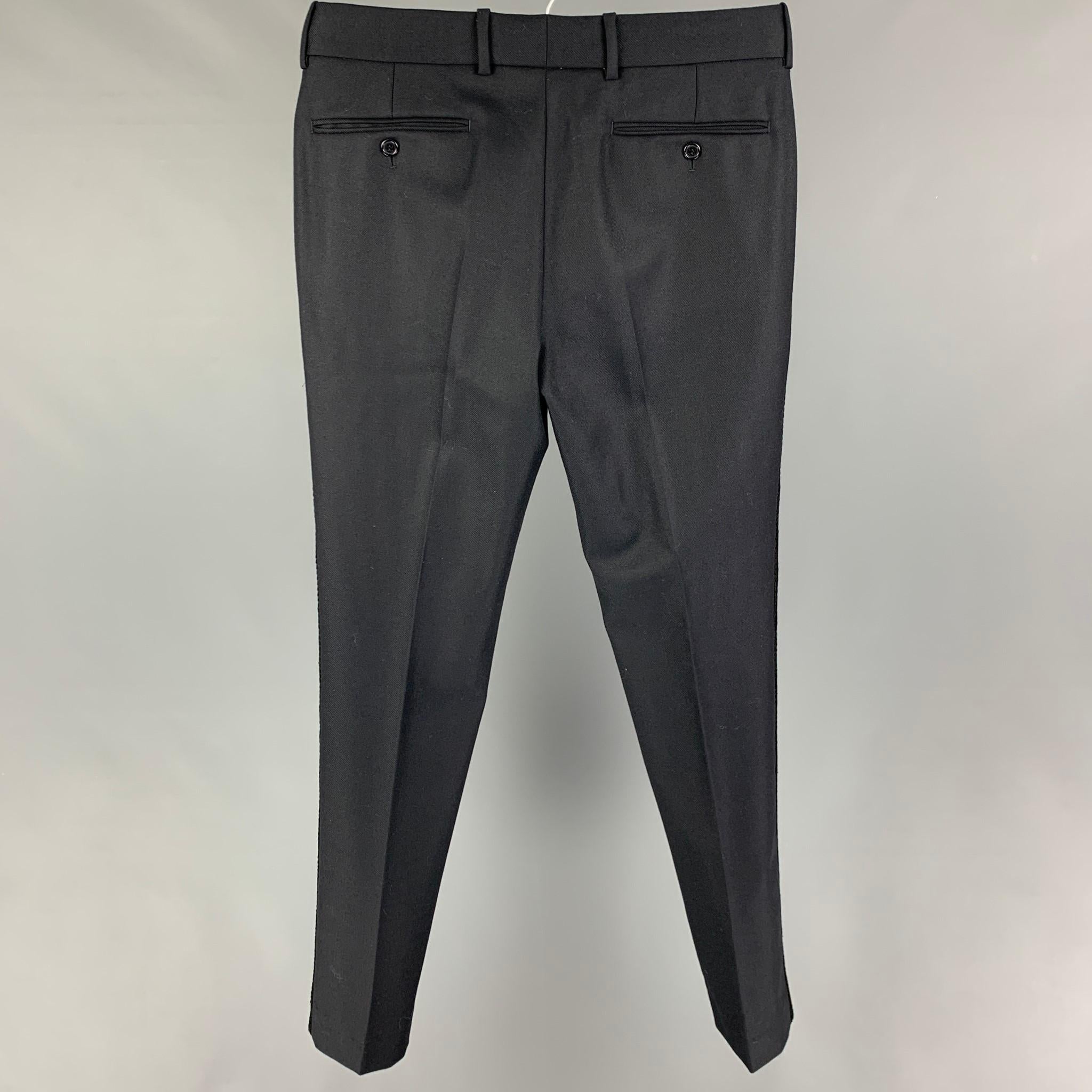 ALEXANDER McQUEEN dress pants comes in a navy wool featuring a flat front, embroidered trim, front tab, and a zip fly closure. Made in Romania. 

Excellent Pre-Owned Condition.
Marked: 46

Measurements:

Waist: 32 in.
Rise: 10 in.
Inseam: 32 in. 