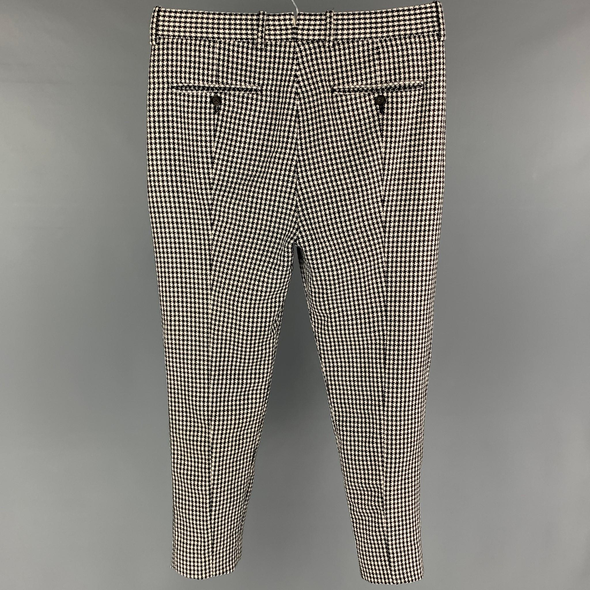 ALEXANDER McQUEEN pants comes in a black & white houndstooth wool featuring a flat front and a zip fly closure. Made in Romania. 

Very Good Pre-Owned Condition.
Marked: 48

Measurements:

Waist: 34 in.
Rise: 12 in.
Inseam: 26 in. 