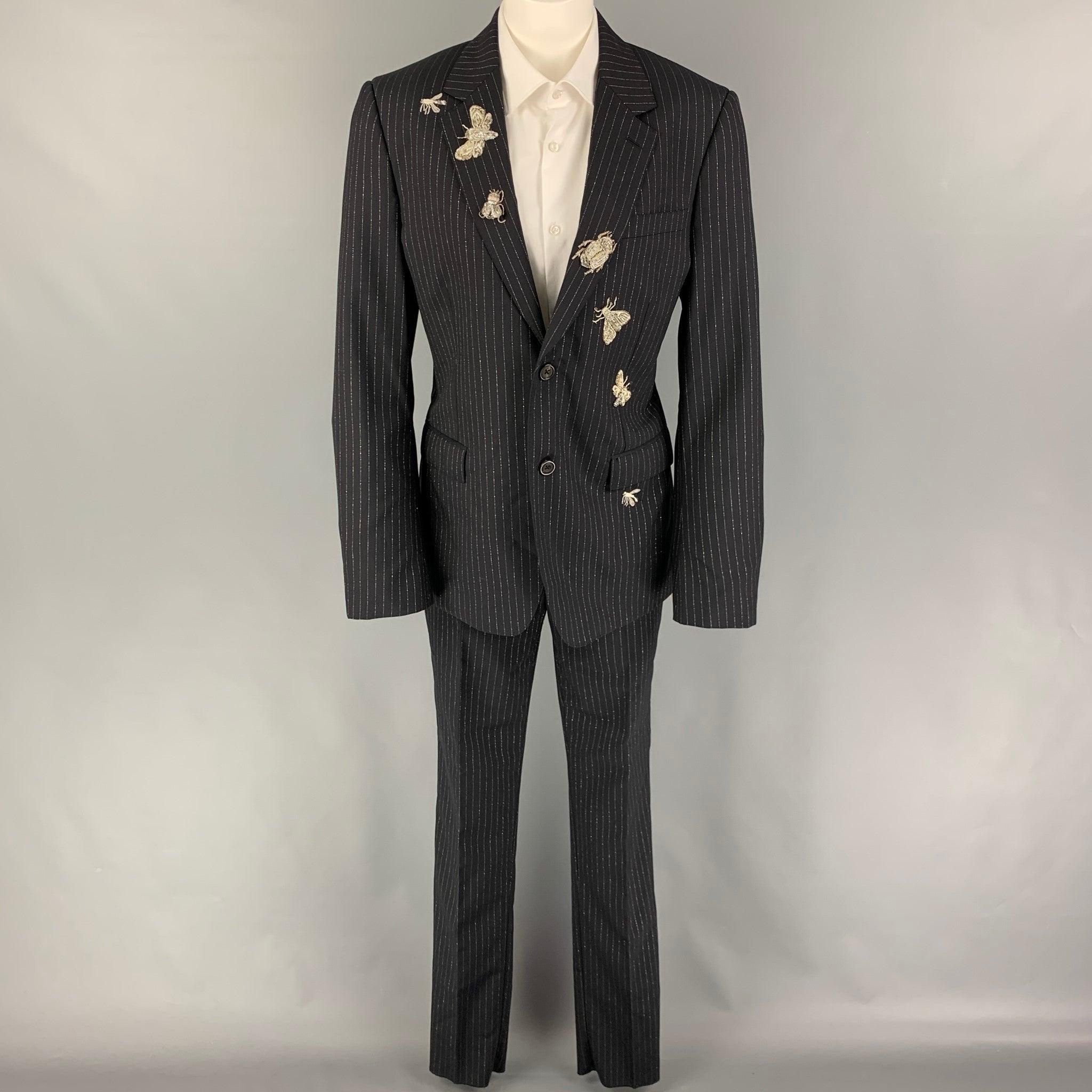 ALEXANDER McQUEEN
suit comes in a black & silver stripe wool blend with beaded insect embellishment details and includes a single breasted, double button sport coat with a notch lapel and matching flat front trousers. Made in Italy. New with tags. 