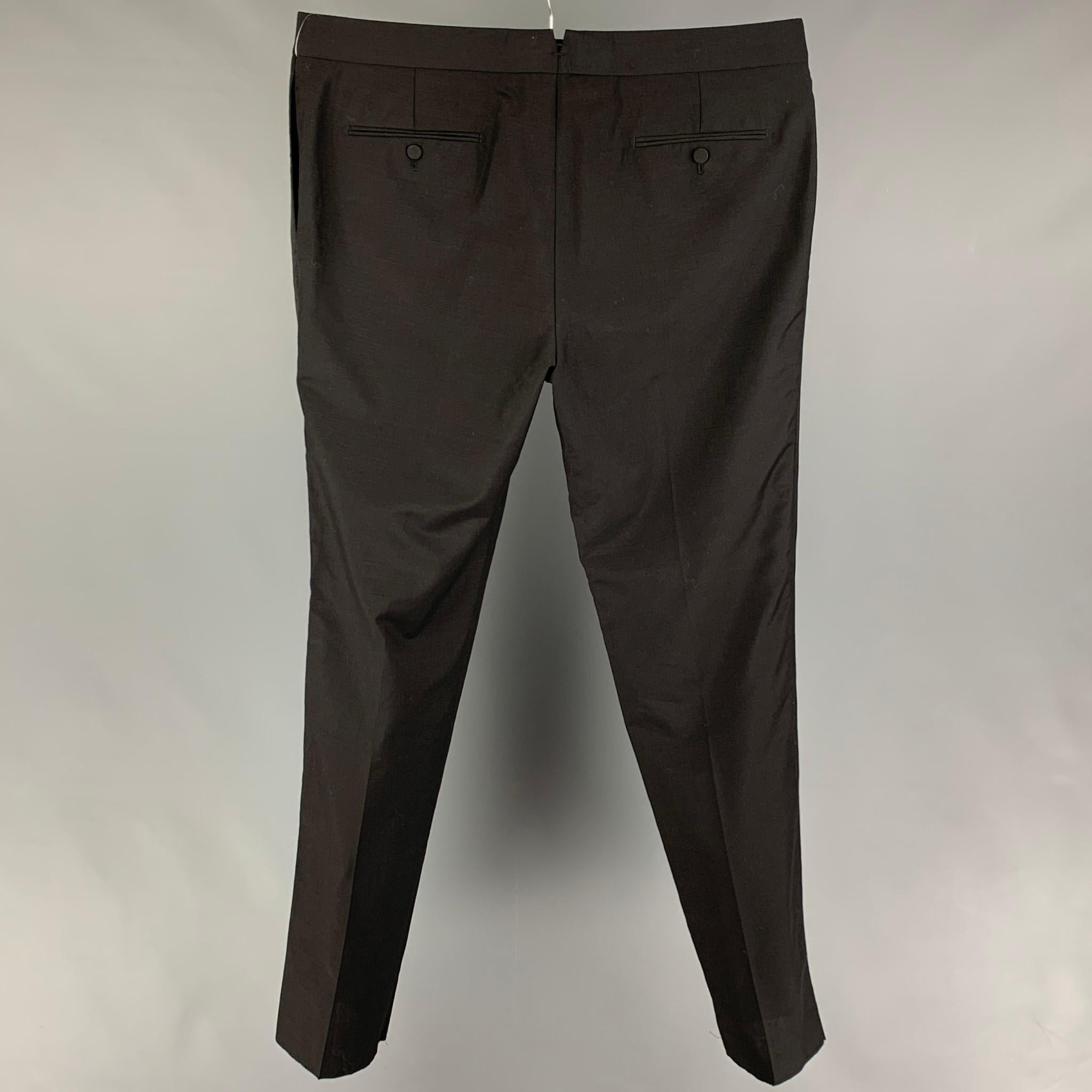 ALEXANDER McQUEEN tuxedo pants comes in a black wool / mohair featuring a flat front, ribbon trim, front tab, and a zip fly closure. Made in Italy. 

Excellent Pre-Owned Condition.
Marked: 58

Measurements:

Waist: 40 in.
Rise: 12.5 in.
Inseam: 37