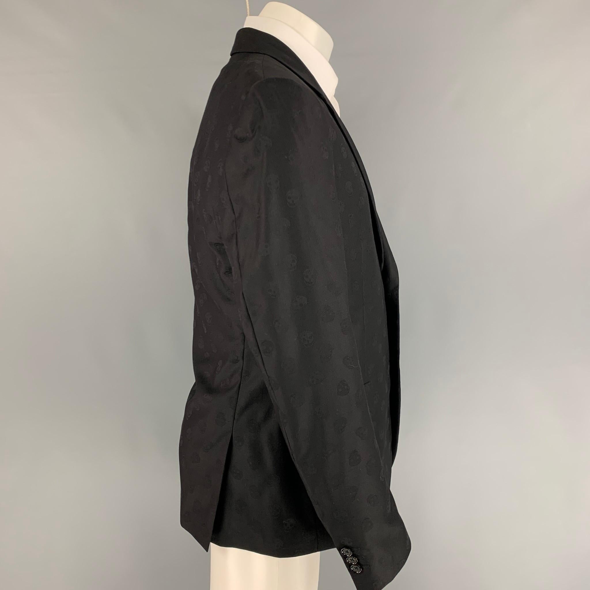 ALEXANDER McQUEEN sport coat comes in a black skull print wool with a full liner featuring a notch lapel, flap pockets, double back vent, and a double button closure. Made in Italy. 

Very Good Pre-Owned Condition.
Marked: