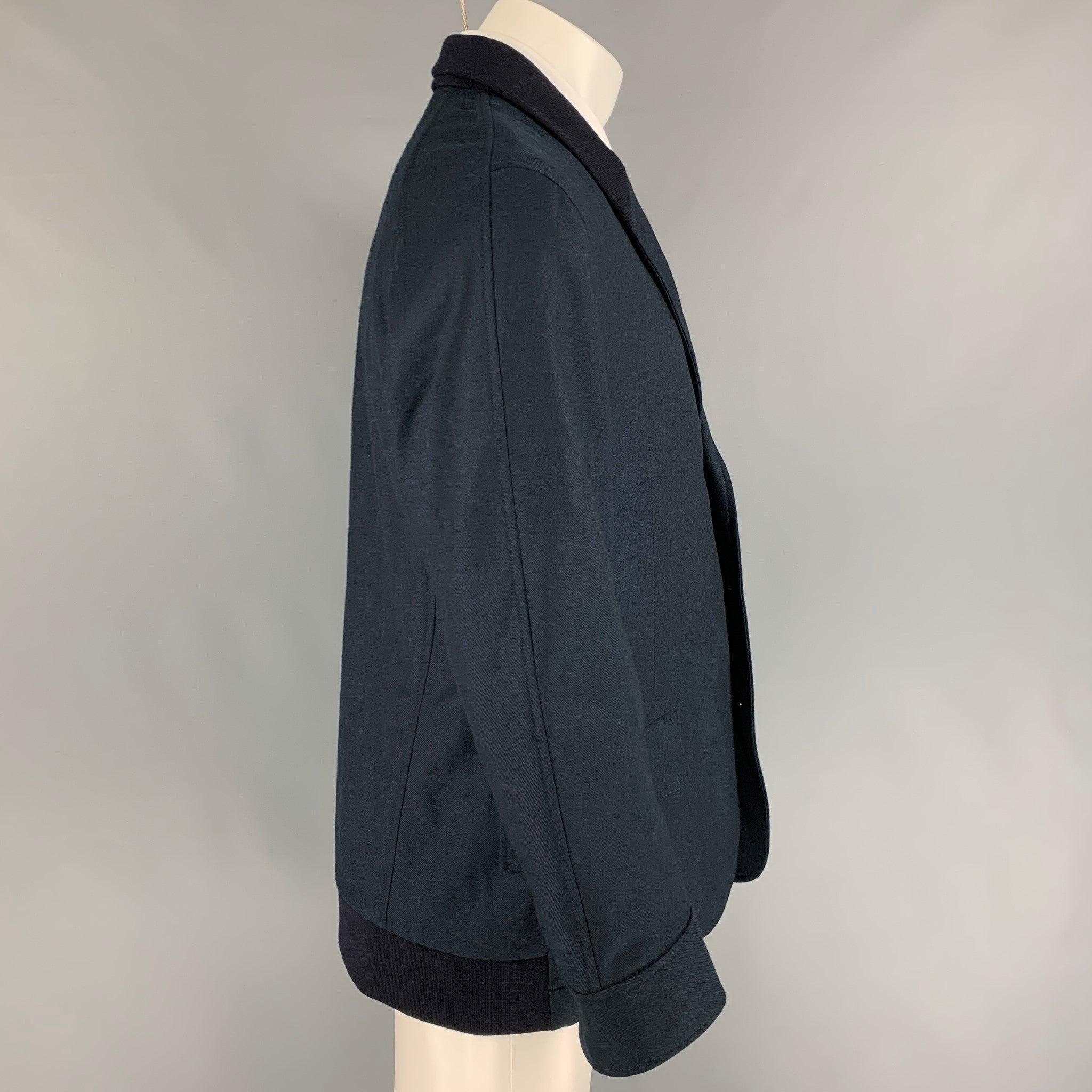 ALEXANDER McQUEEN sport coat comes in a navy wool featuring a hybrid jacket design, ribbed collar, flap pockets, and a three button closure. Made in Italy.
Excellent
Pre-Owned Condition.  

Marked:   54 

Measurements: 
 
Shoulder: 18.5 inches 