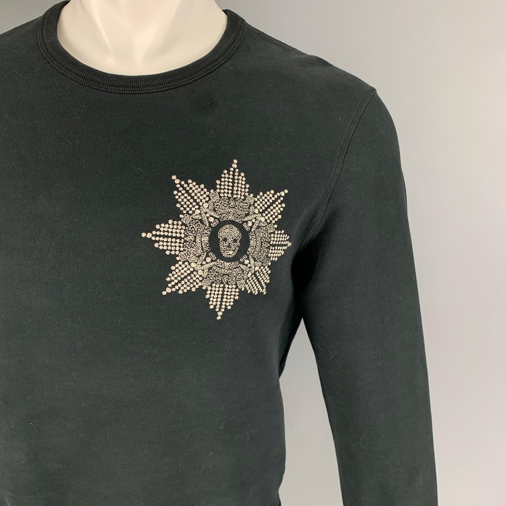 ALEXANDER McQUEEN pullover comes in a black cotton featuring a silver embroidered skull patch and a crew-neck. Made in Italy. 

Very Good Pre-Owned Condition. Light wear at front.
Marked: M

Measurements:

Shoulder: 19 in.
Chest: 40 in.
Sleeve: 26