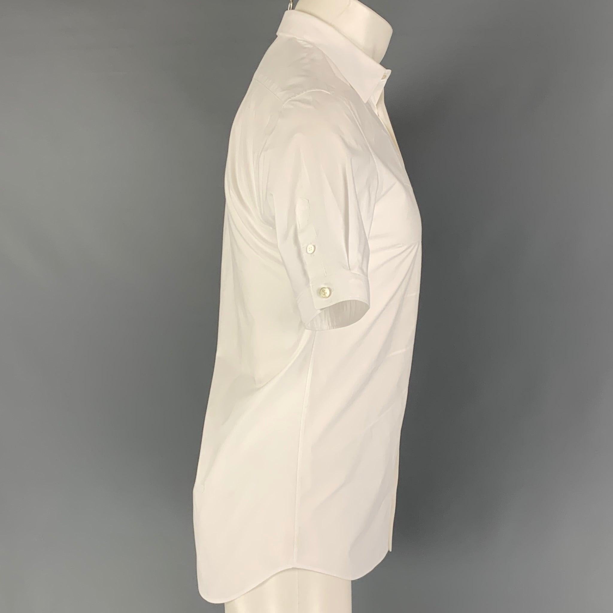 ALEXANDER McQUEEN short sleeve shirt comes in a white cotton featuring top stitching designs, buttoned sleeves, and a button up closure. Made in Romania.Very Good
Pre-Owned Condition. 

Marked:   15 

Measurements: 
 
Shoulder: 16 inches  Chest:
36