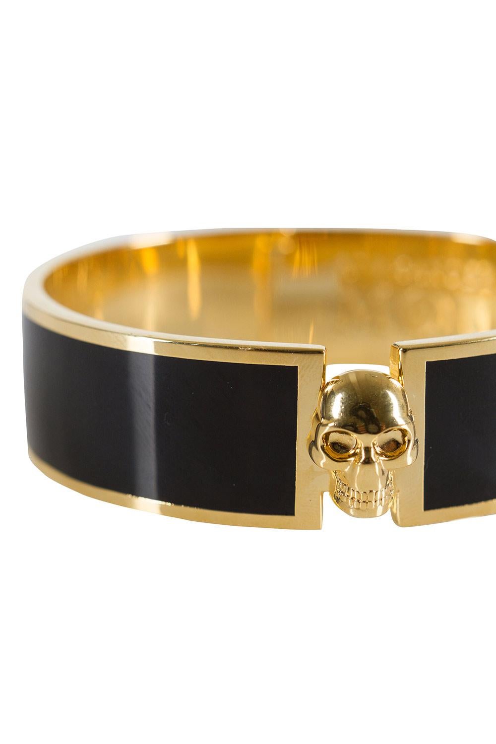 Alexander McQueen's penchant for using skull motifs is seen not only in clothes and shoes but also in their line of accessories. Carrying the very signature is this bracelet sculpted from gold-tone metal and enhanced with black resin and a skull