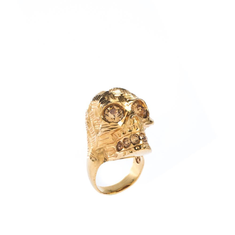 Quirky and very stylish, this ring from Alexander McQueen is here to enchant you and make you fall in love with it. The fabulous creation is crafted from gold-tone metal and shines with a crystal-embellished skull at the front. A piece worth